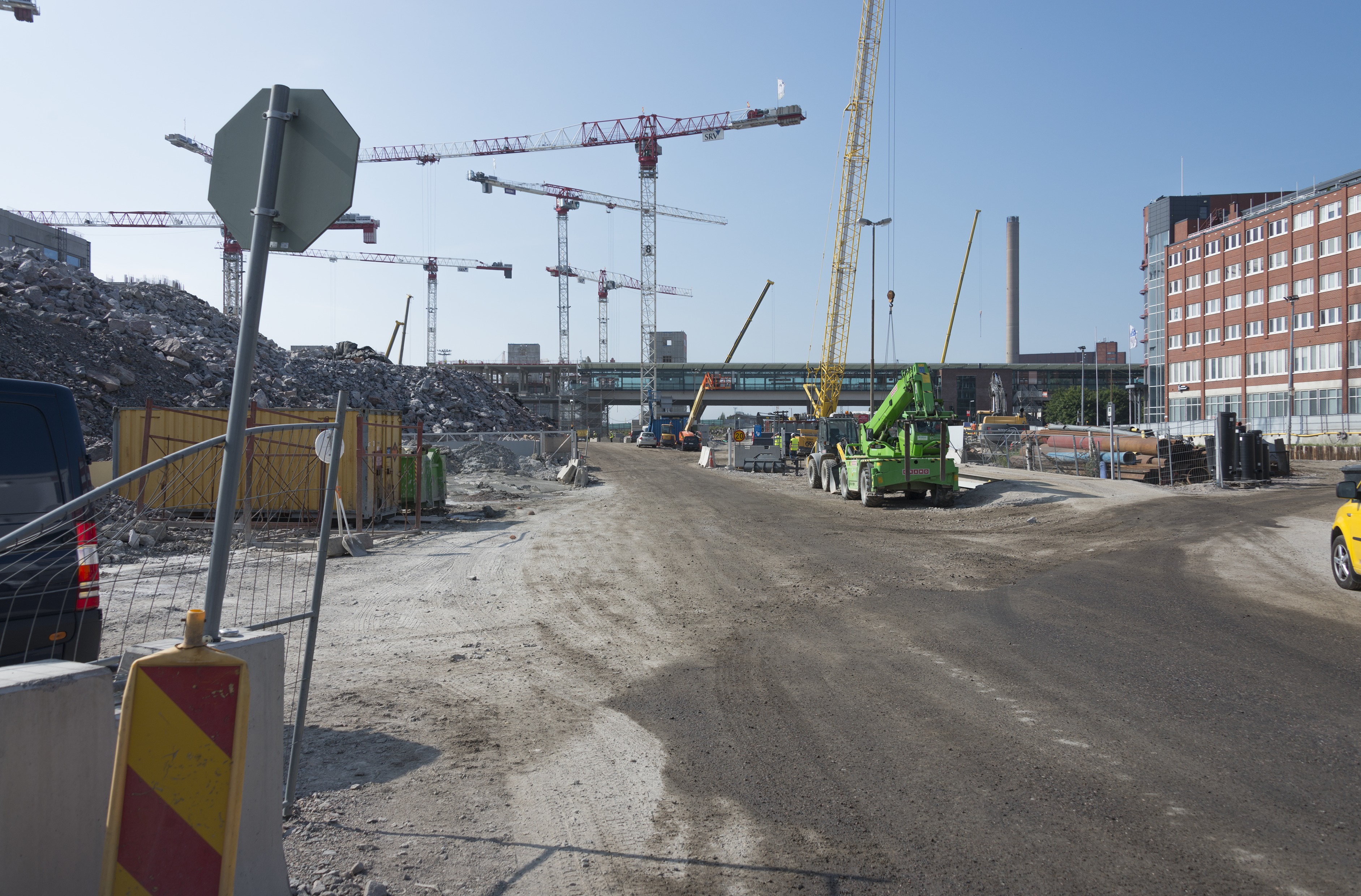 Kalasataman dokumentointi. Hermannin rantatie, Kalasataman keskuksen rakennustyömaa, Kalasataman metroasema, Helsingin yrittäjätalo, nostureita. Taustalla Hanasaaren voimalaitoksen piippu.