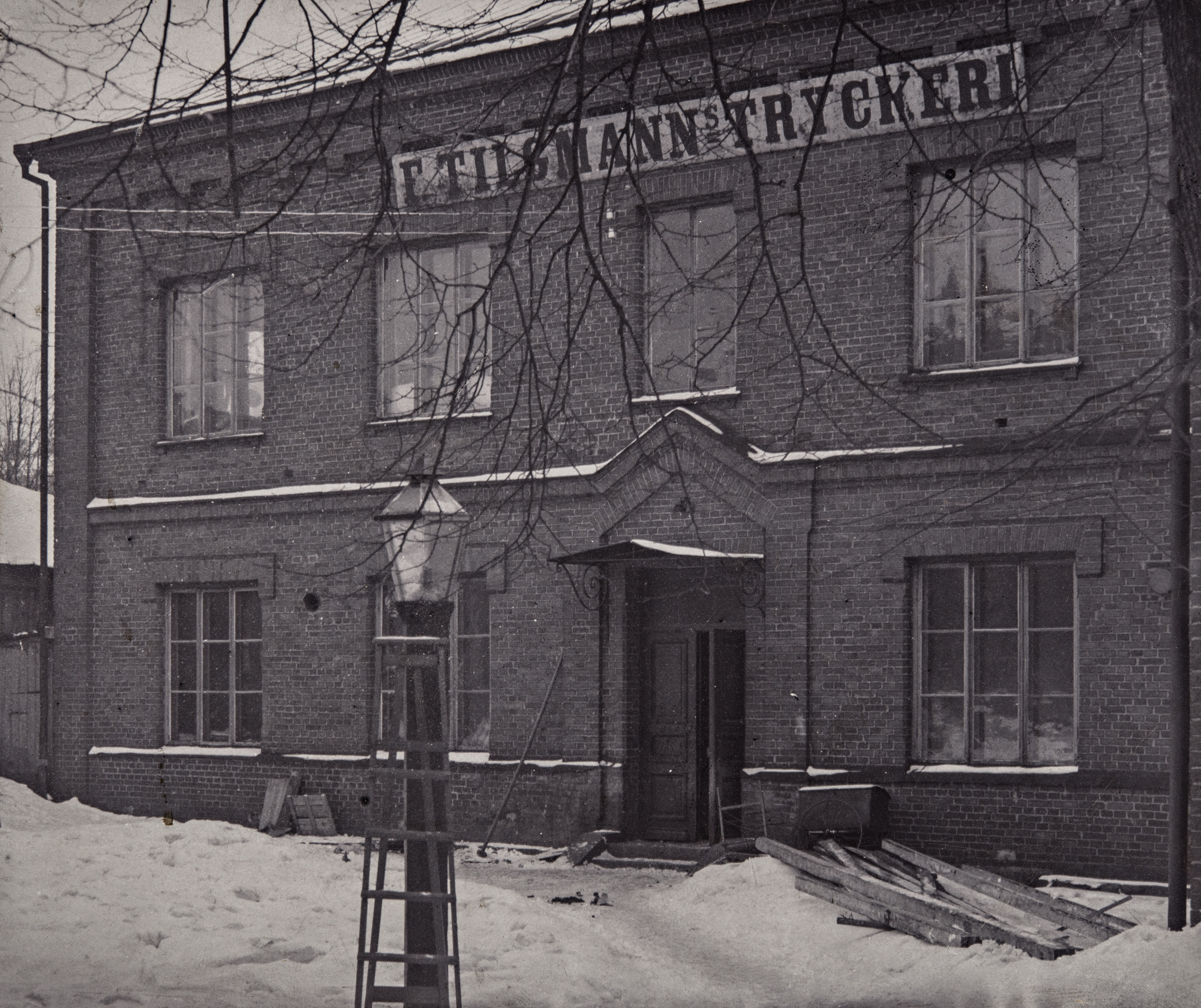 F. Tilgmannin Kirja- ja Kivipaino sekä Kemigrafinen Laitos Oy, Antinkatu (Lönnrotinkatu) 10.  Tilgmannin painotalon tilat kävivät ahtaiksi 1900-luvun alussa, 1920-luvulla rakennettiin Lönnrotinkadun varrelle punatiilinen laajennusosa.