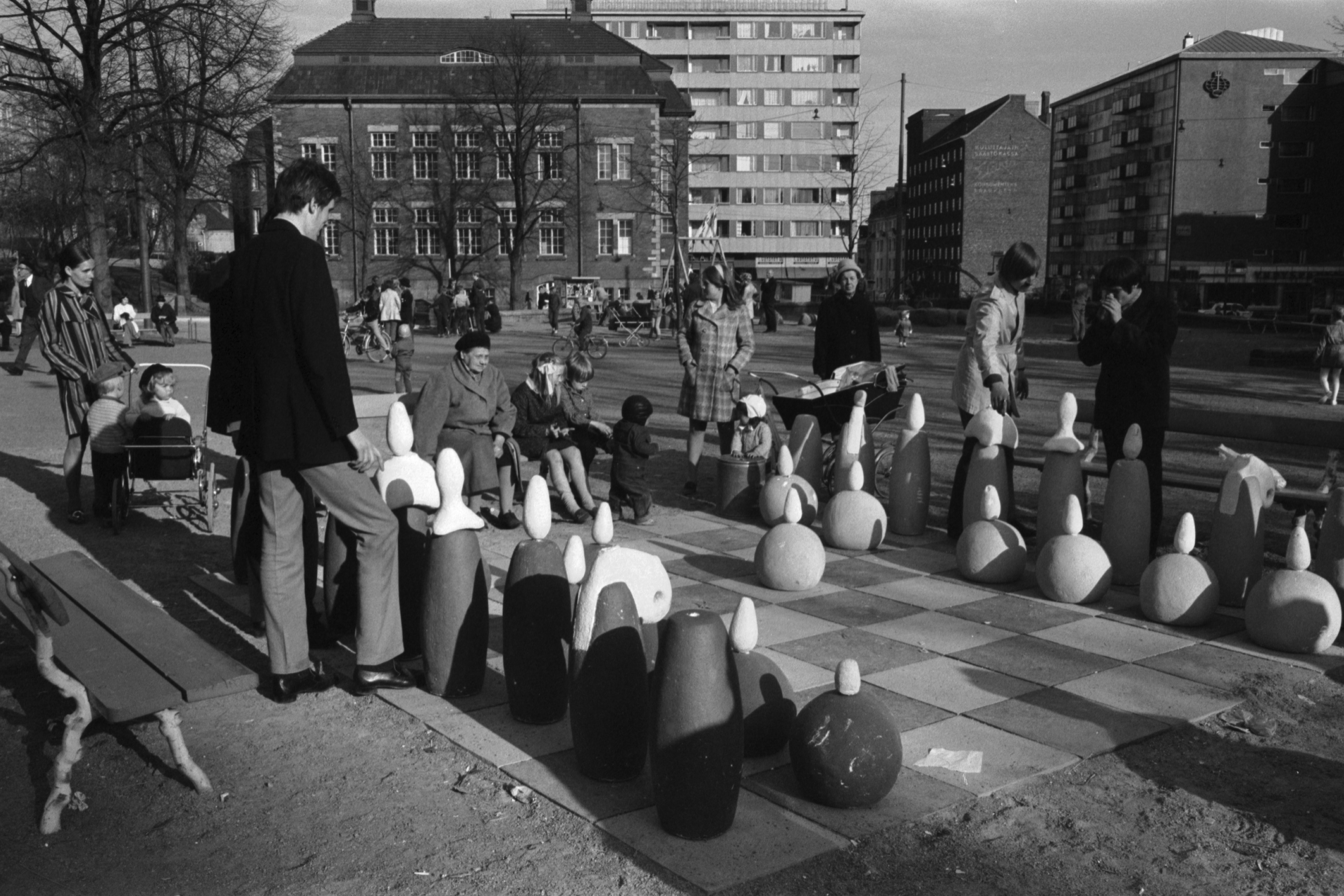 Karhupuisto. Helsingin juhlaviikot. Suuren shakkilaudan nappulat on saatu järjestettyä ja peli voi alkaa Karhupuistossa.