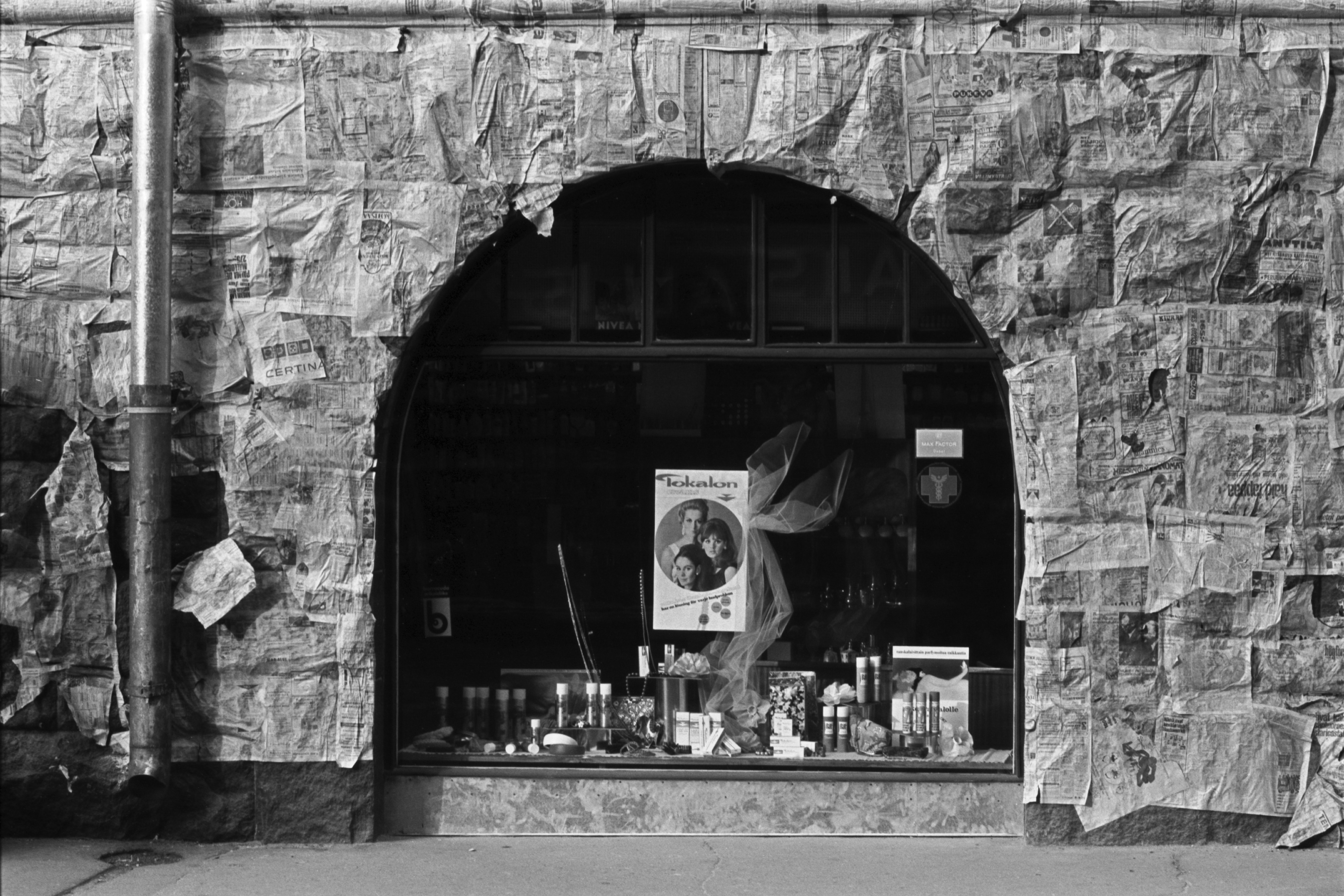 Kruunuvuorenkatu 1. Kruunuvuorenkatu 1:ssä sijaitsevan kemikaliokaupan näyteikkuna talon kivijalassa, joka on suojattu sanomalehdillä maalaustöiden ajaksi.