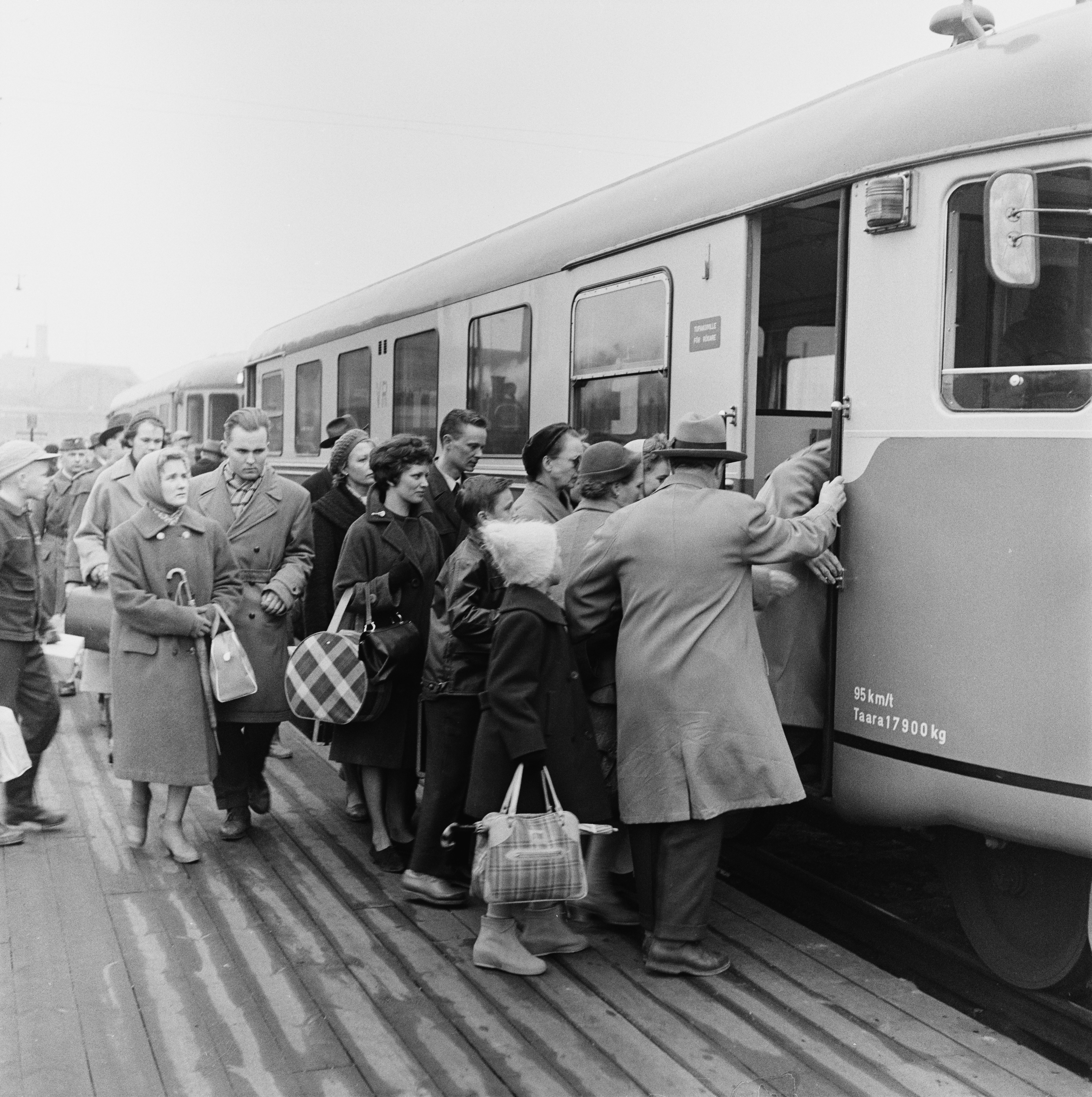 Matkustajia nousemassa kiskobussiin eli lättähattuun Helsingin rautatieasemalla.