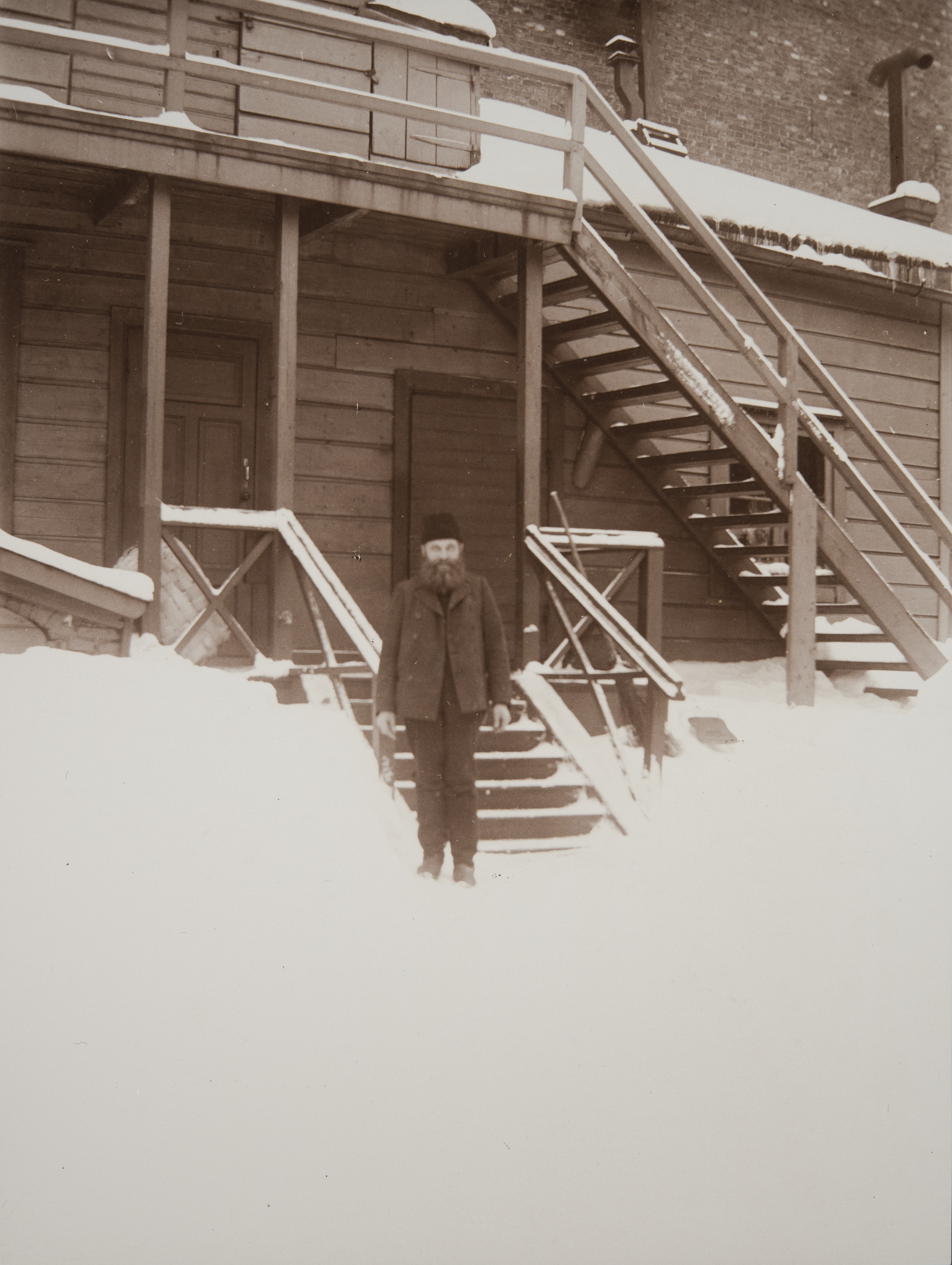 Läntinen Rantakatu 14:n (nykyisin Eteläranta) piharakennus ja sen edessä seisova mies talvisessa kuvassa.