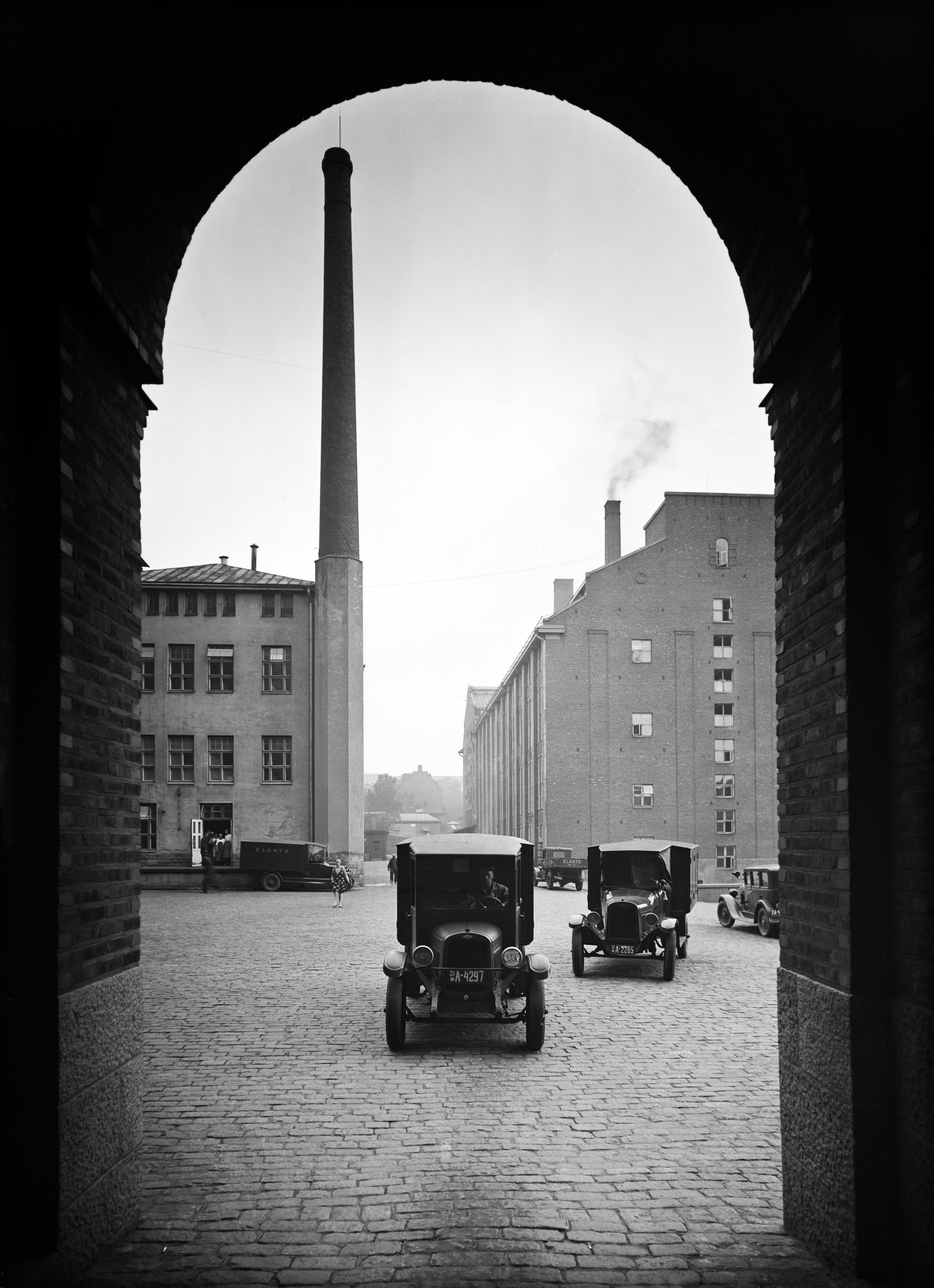 Elannon hallintorakennuksen portti tehdaspihalle. Vasemmalla on kalja- ja virvoitusjuomatehtaan siipi, oikealla leipomo. Kaikukatu 2.