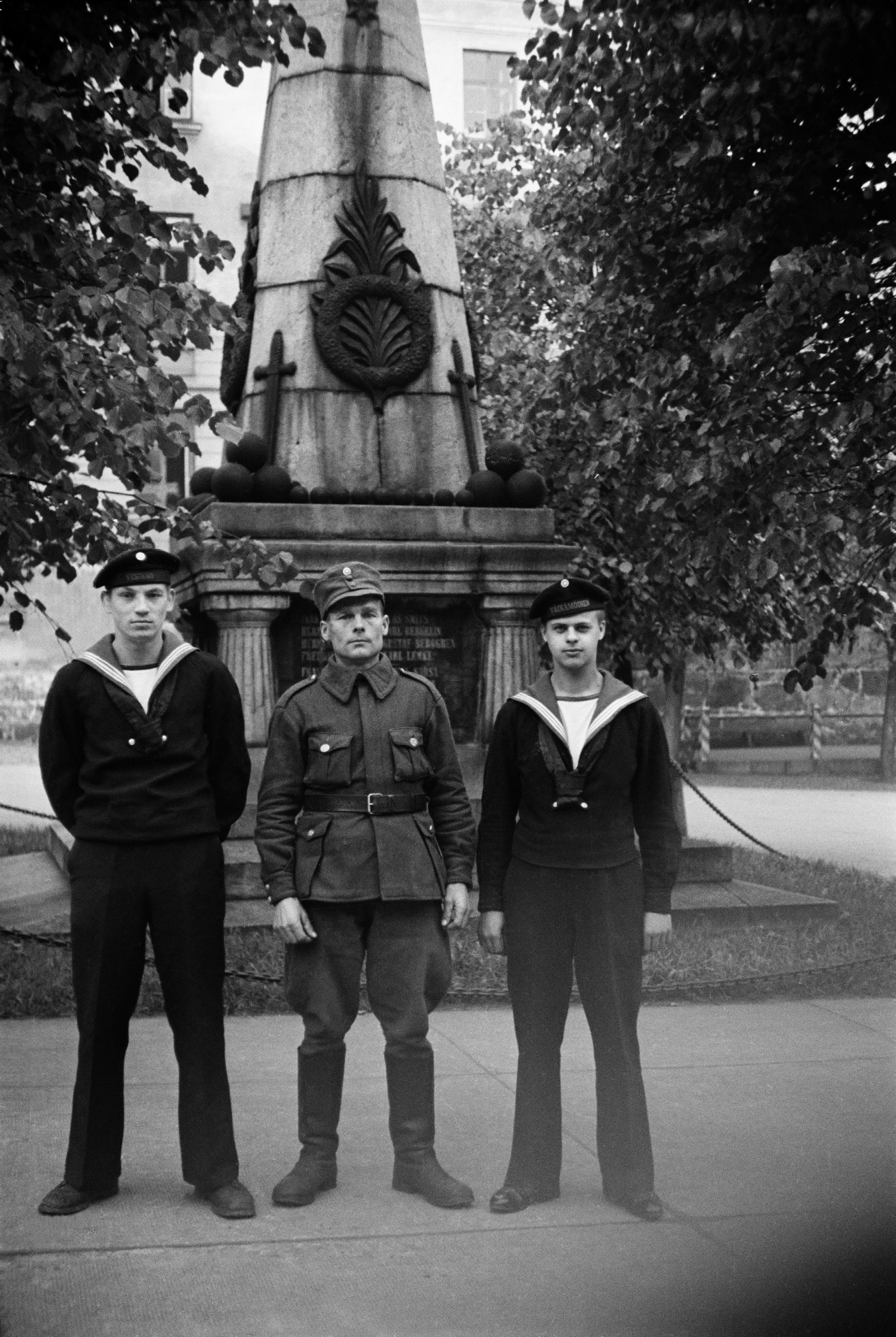 Sotilas ja kaksi merisotilasta seisovat Gornyi Dubnjakin (Gornij Dubnjakin) taistelun muistomerkin edessä Kaartin kasarmin pihalla (nyk. puolustusministeriön päärakennus).