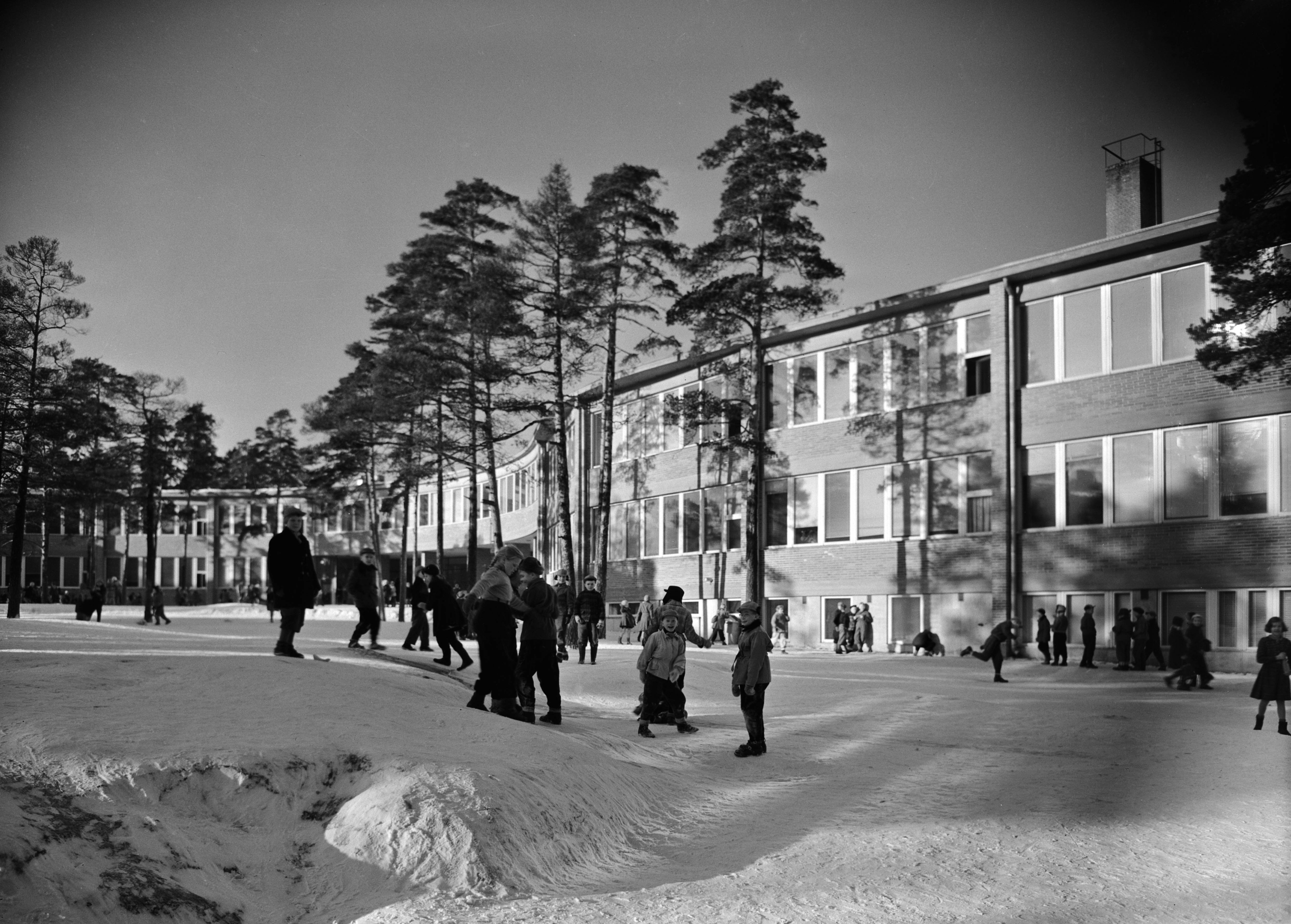 Lapsia Meilahden kansakoulun pihalla. Rakennuksen olivat suunnitelleet arkkitehdit Osmo Sipari ja Viljo Revell (ko kohteen arkkitehtikilpailun voittajat), kaarevarunkoinen koulu rakennettiin vuosina 1949-1953.