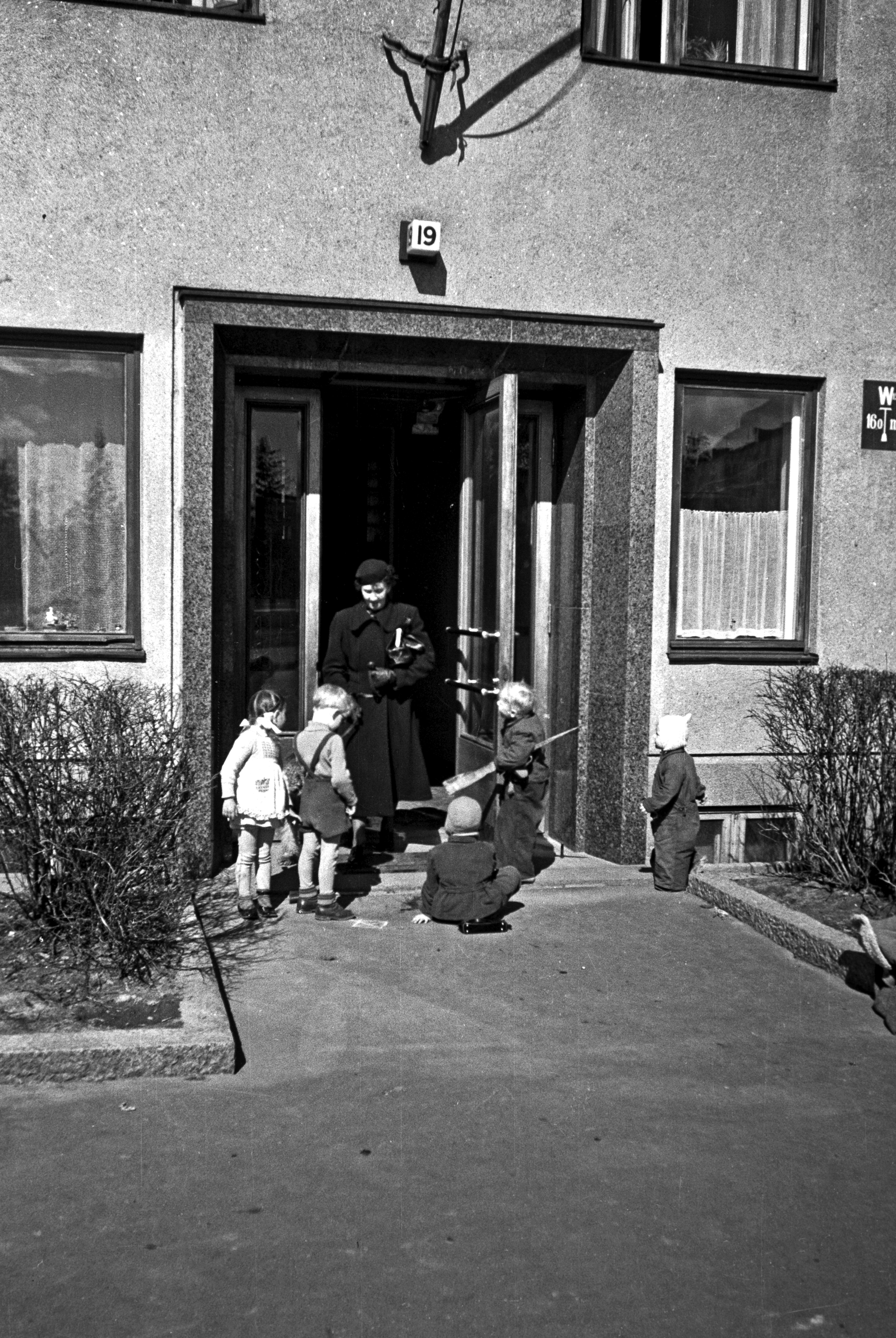 Lapsia ja nainen Humalistonkatu 19 ovella.