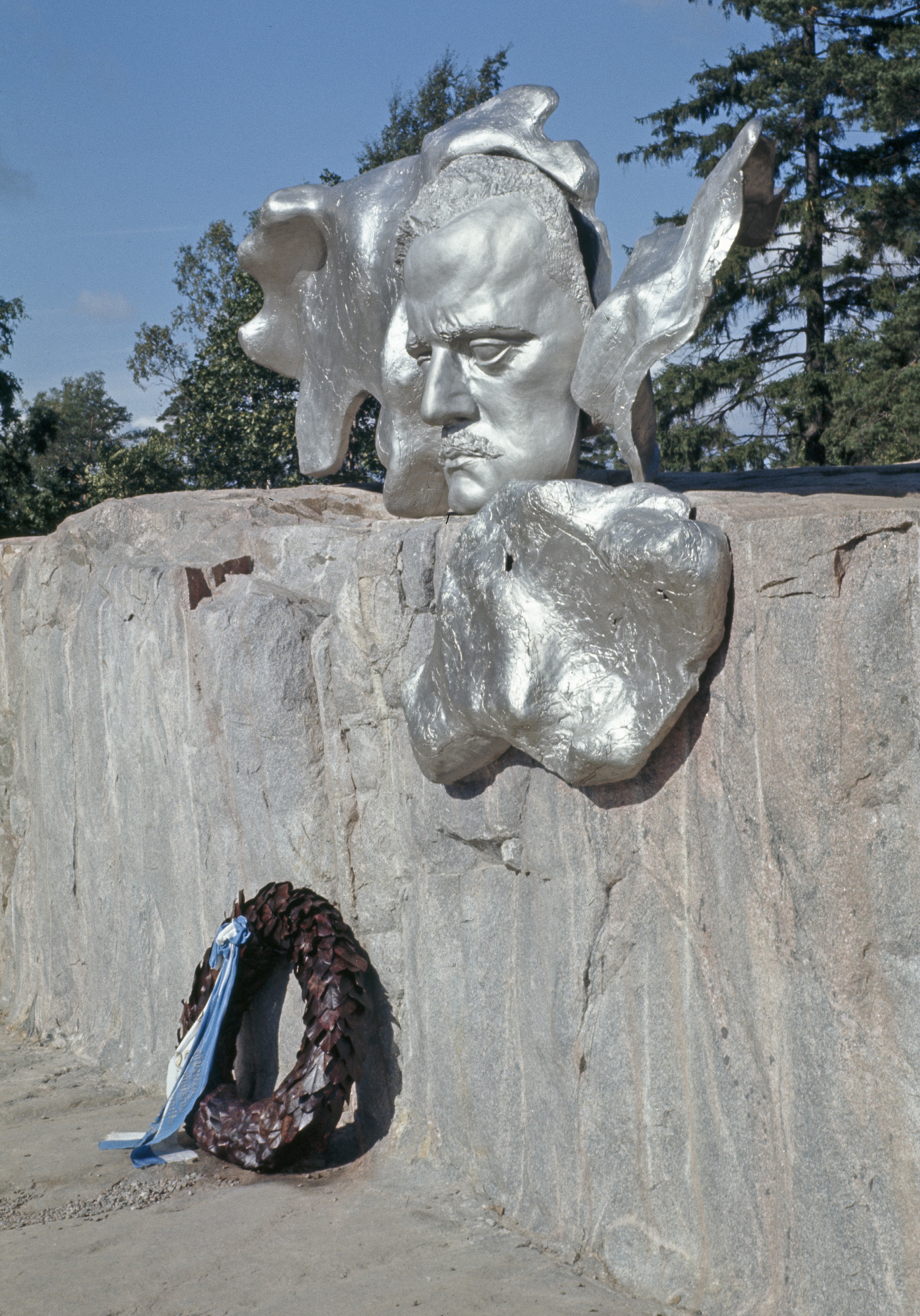 Sibeliuksen puisto, Sibelius-monumentti. Lähikuva kasvoreliefistä, jonka juuressa muistoseppele.