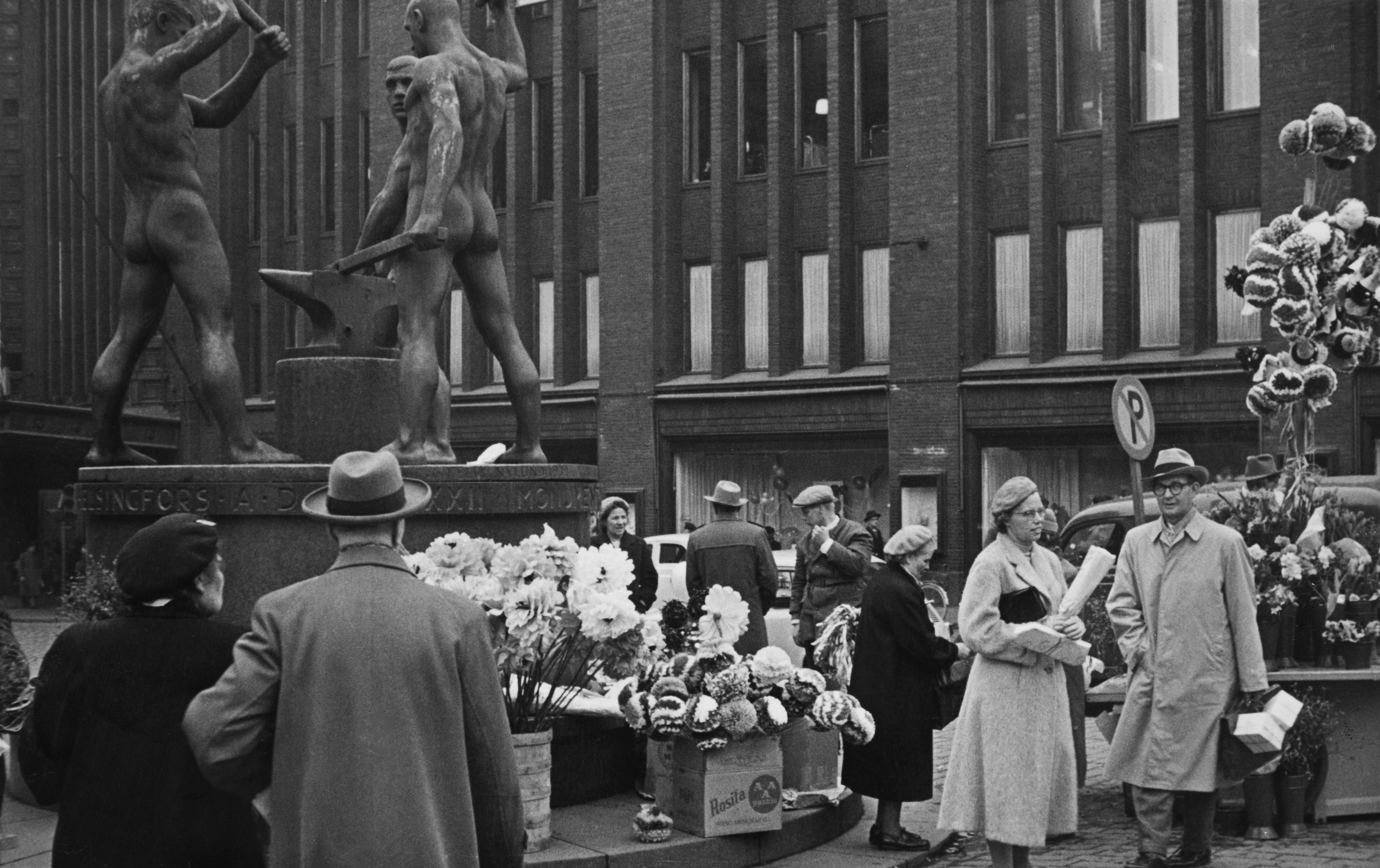 Vapputarvikkeiden myyntiä Kolmen sepän patsaan vieressä vapunaattona. Taustalla Stockmannin tavaratalo.