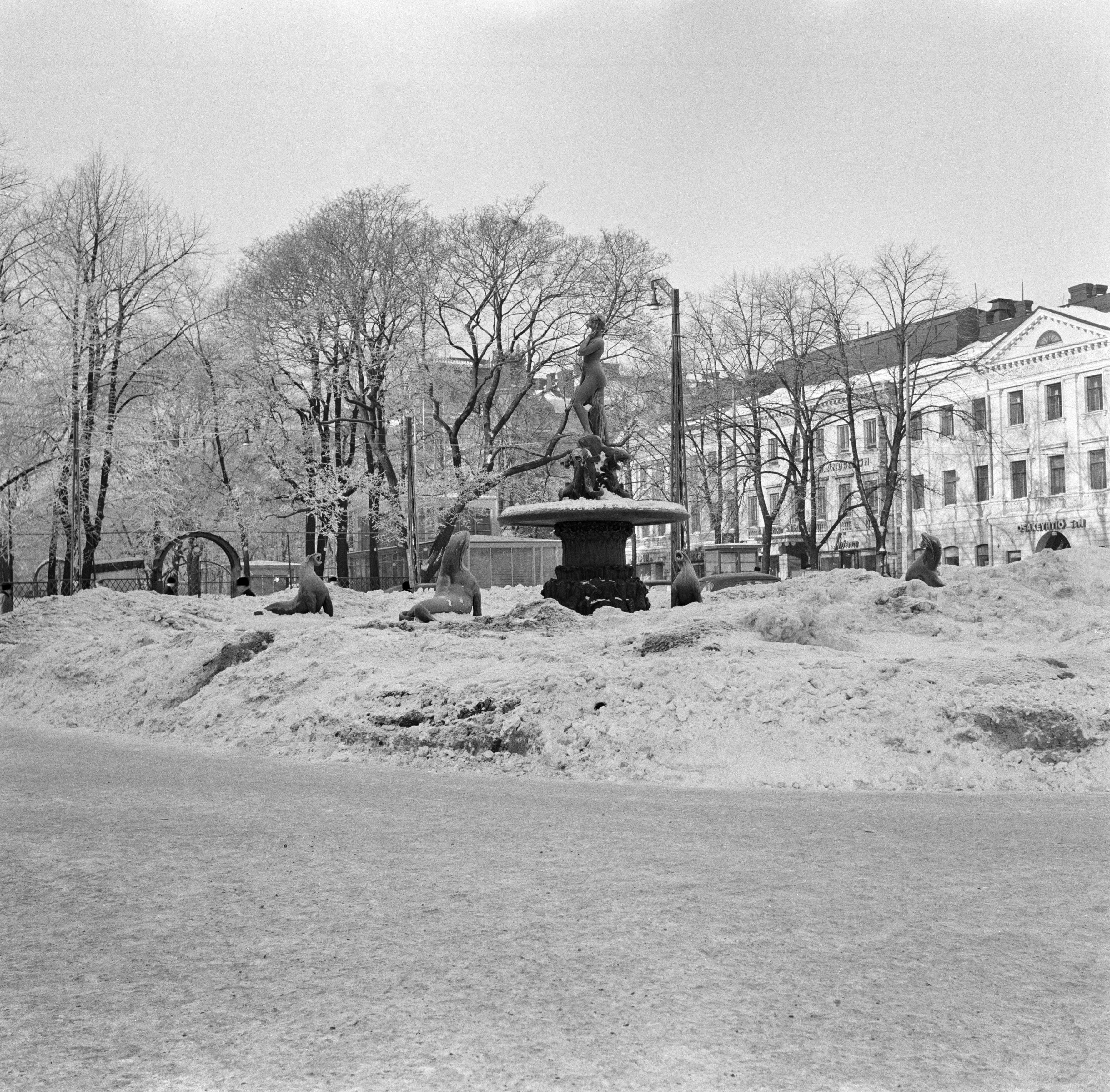 Kauppatori, talvinen näkymä kohti Havis Amandan patsasta ja suihkulähdettä. Taustalla Kappeliesplanadi, oikealla Pohjoinen Esplanadikatu (=Pohjoisesplanadi) 23, 21 ja 19 (=ns. Uschakoffin talo).