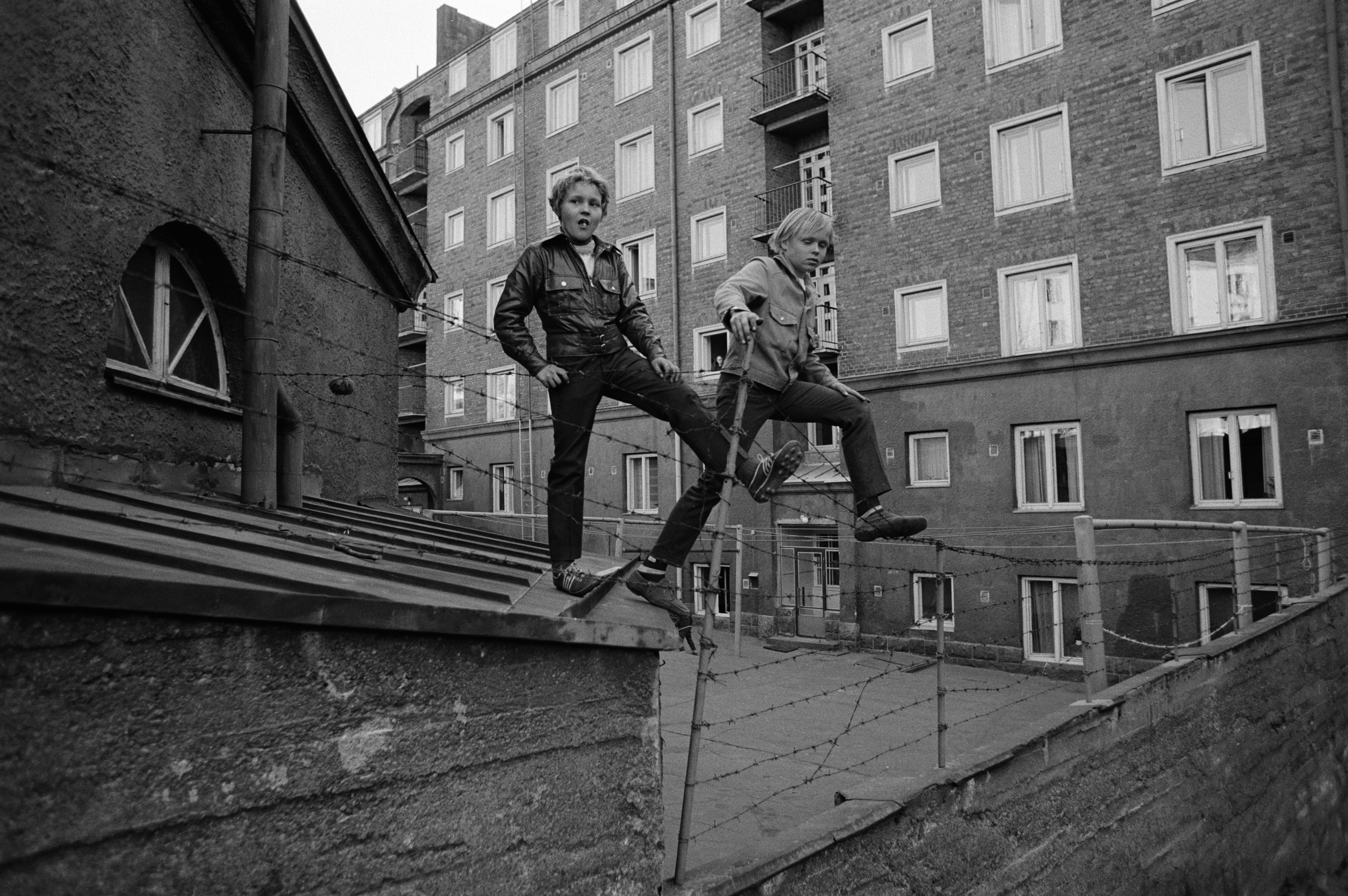 Kaksi poikaa seisomassa pihojen välisellä välipiikkilanka-aidalla Torkkelinmäessä Kalliossa. Fleminginkatu 11, 13. Kevät 1970.