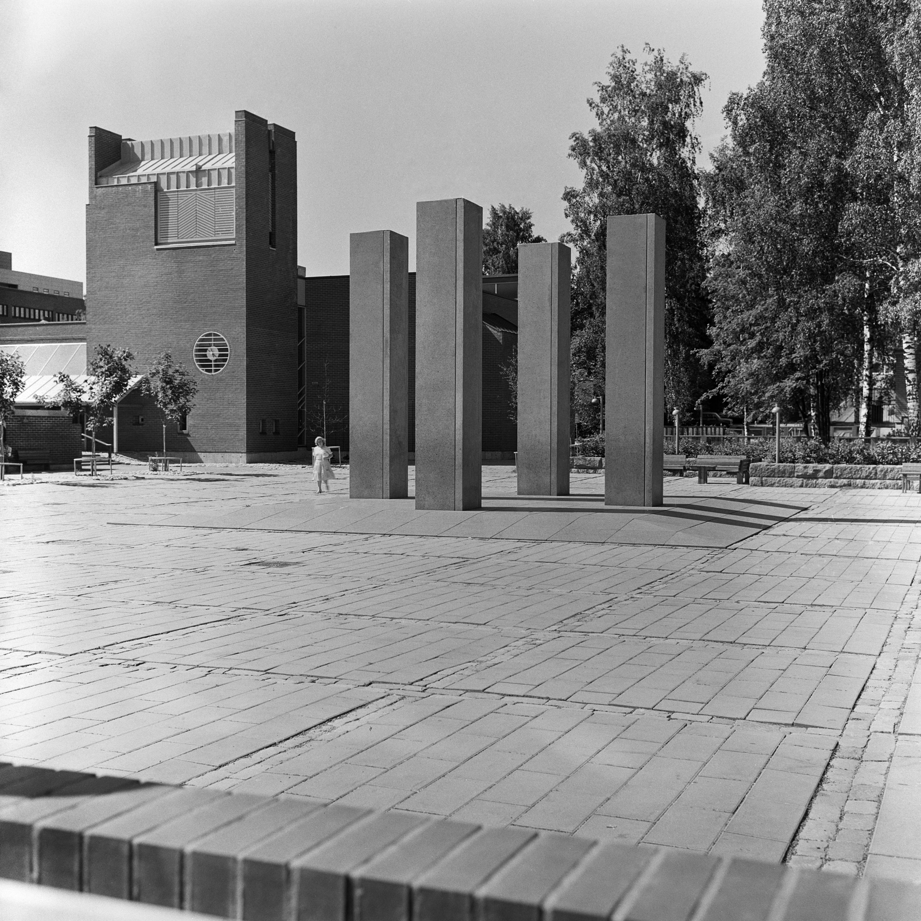 Hannu Siren: Stoa (kivi, 1984). Itä -Helsingin kulttuurikeskus Stoa, Itäkeskus. Taustalla Matteuksenkirkko.