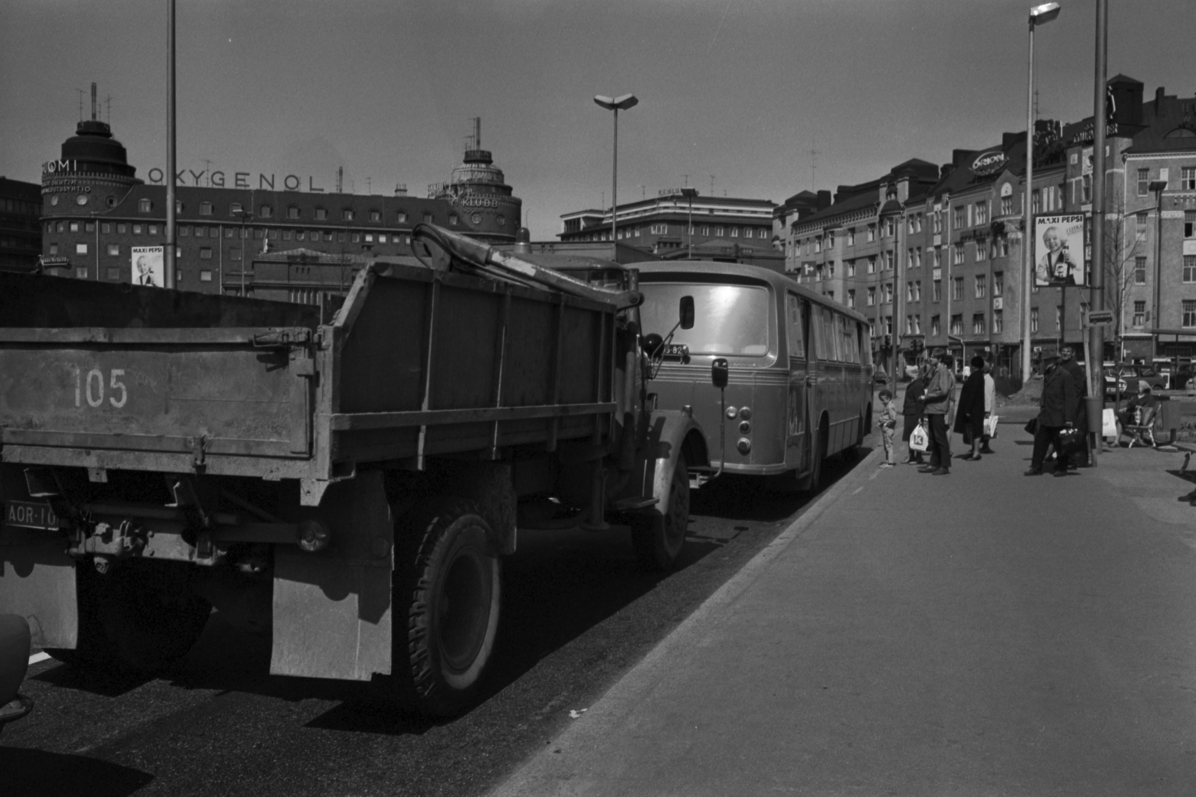 Hakaniemen torikatu. Kuorma-auto ja bussi pysäkillä Hakaniementorin laidalla.