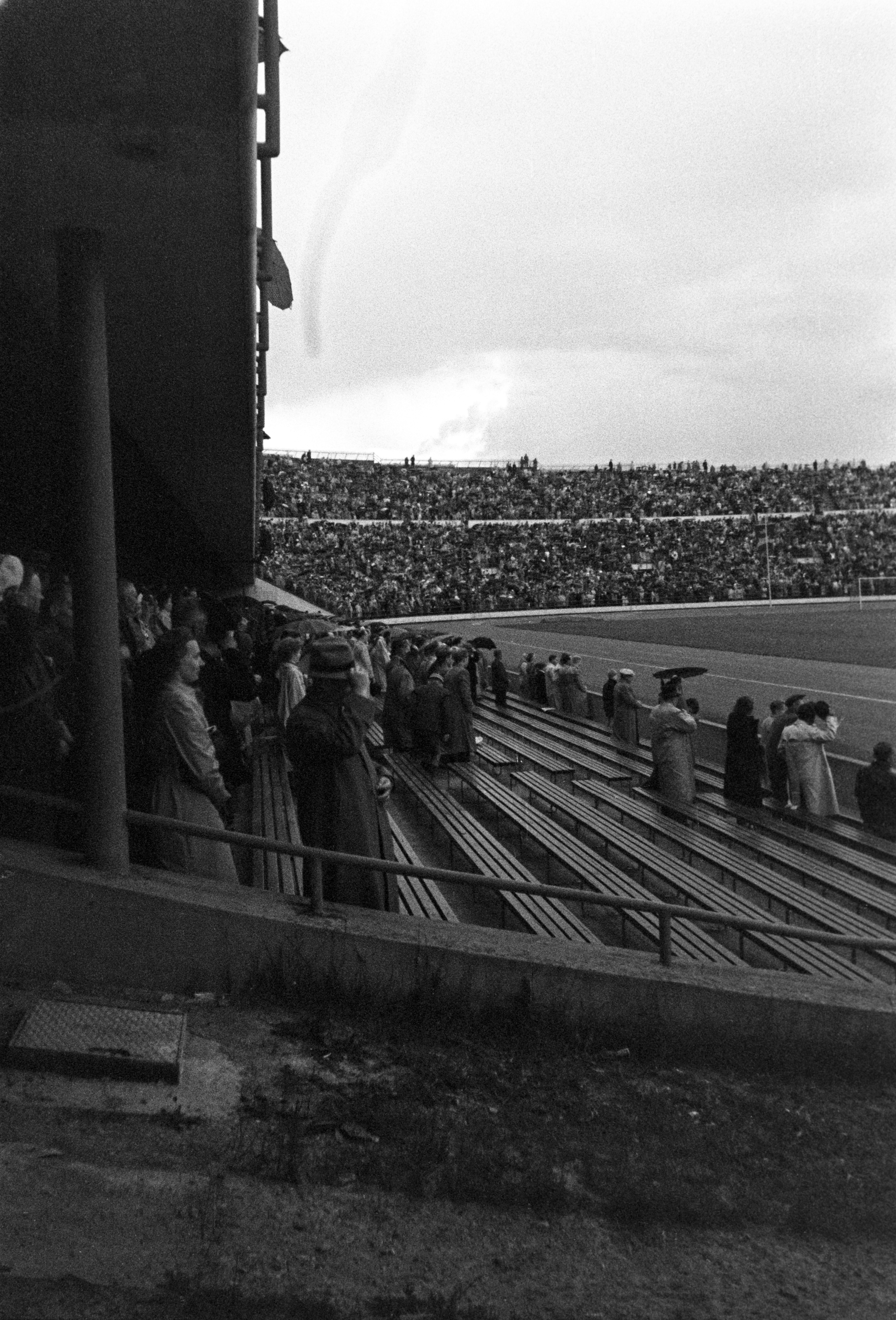 Olympiastadion Helsingin 400-vuotisjuhlien aikaan. Yleisö katsomossa noussut seisomaan, osa nostaa hattua.
