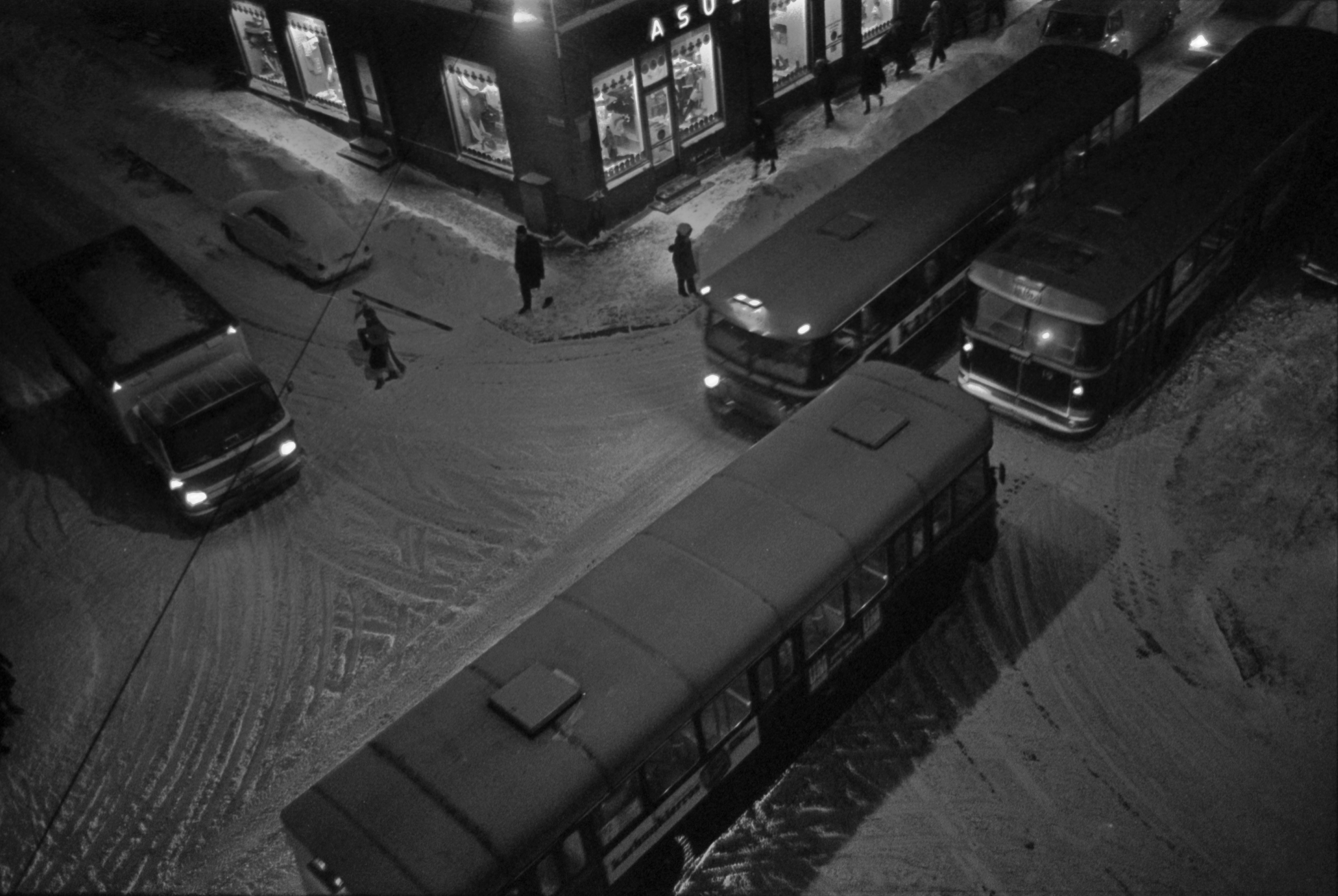 Liisankatu 6. Meritullinkatu 24. Busseja, autoja ja jalankulkijoita talvi-iltana lumisen Liisankadun ja Meritullinkadun risteyksessä. Kuvattu Ristan olohuoneen ikkunasta.