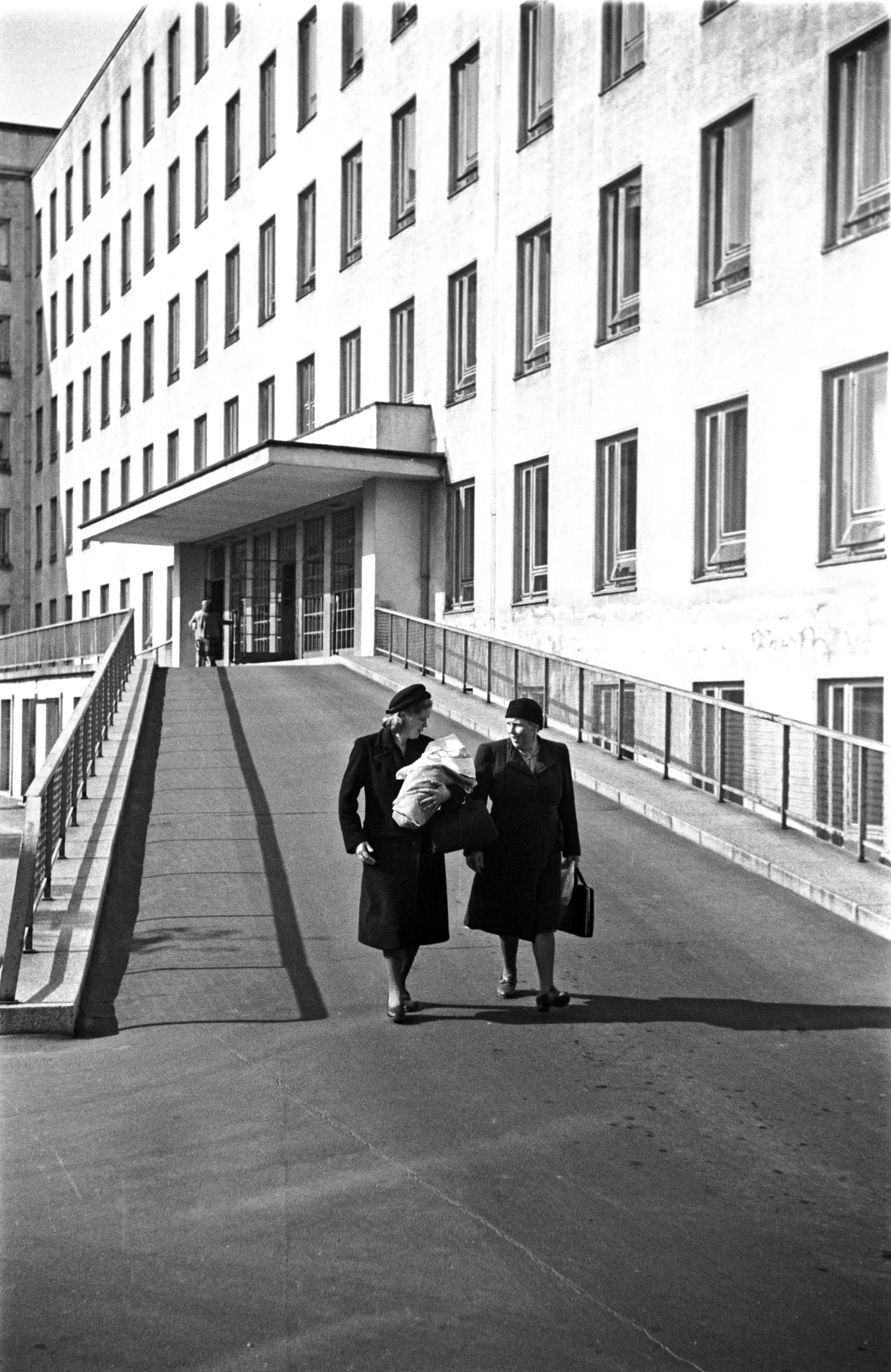 Naistenklinikka, Haartmaninkatu 2. Kaksi naista kävelemässä alas Naistenklinikan pihan puolella olevaa ramppia. Toisella vauva sylissä.