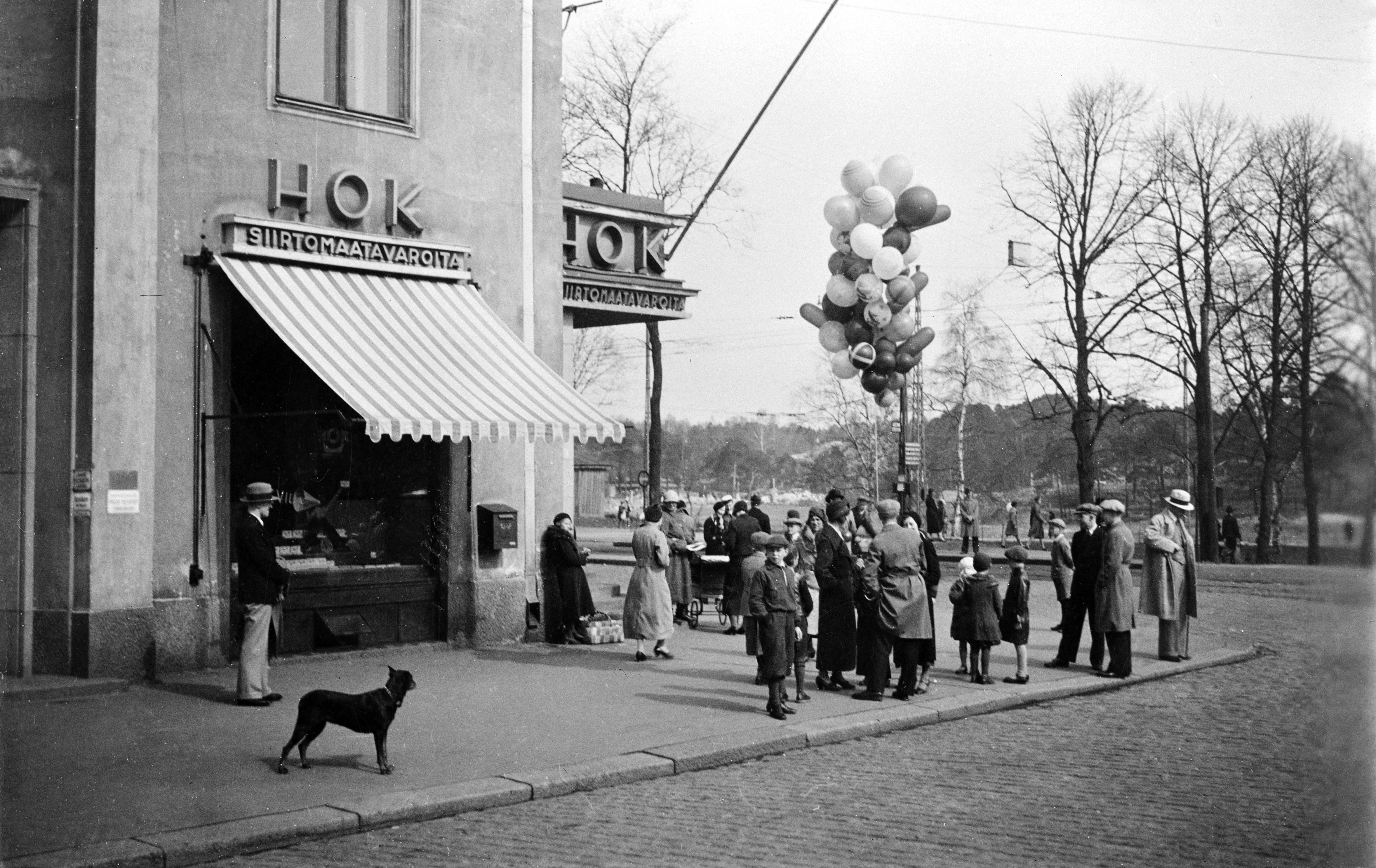 Ilmapallojen myyntiä vappuna 1934 HOK:n kulmassa, Turuntie (= Mannerheimintie 58) -Runeberginkatu 60. Kuvattu Runeberginkadulta.