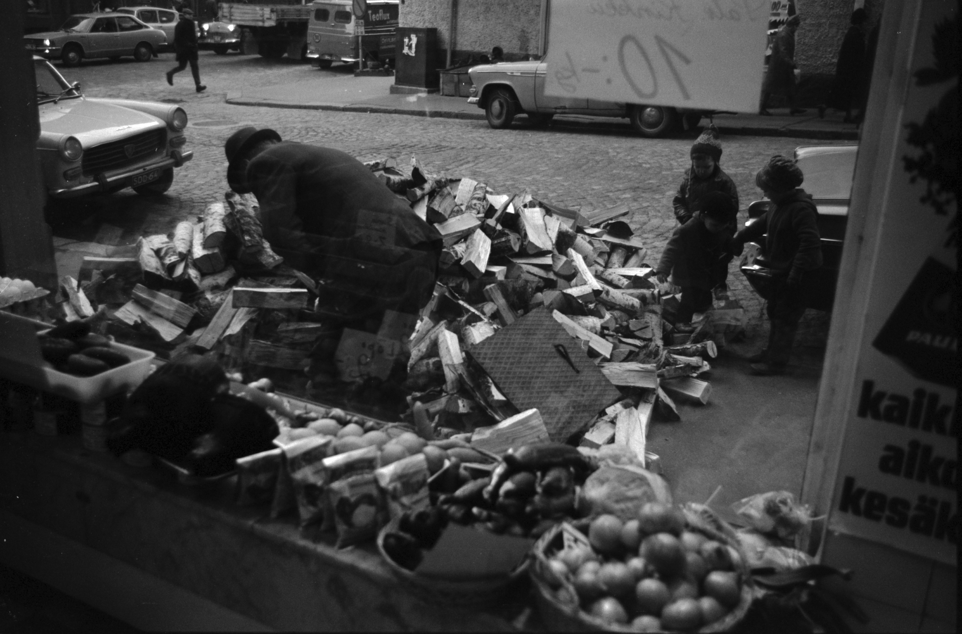 Kruununhaka, Meritullinkatu 25. Talonmies Ville Sneck latomassa jalkakäytävälle kumottuja klapeja kellarin luukusta sisään Meritullinkadulla Liisankadun kulmassa