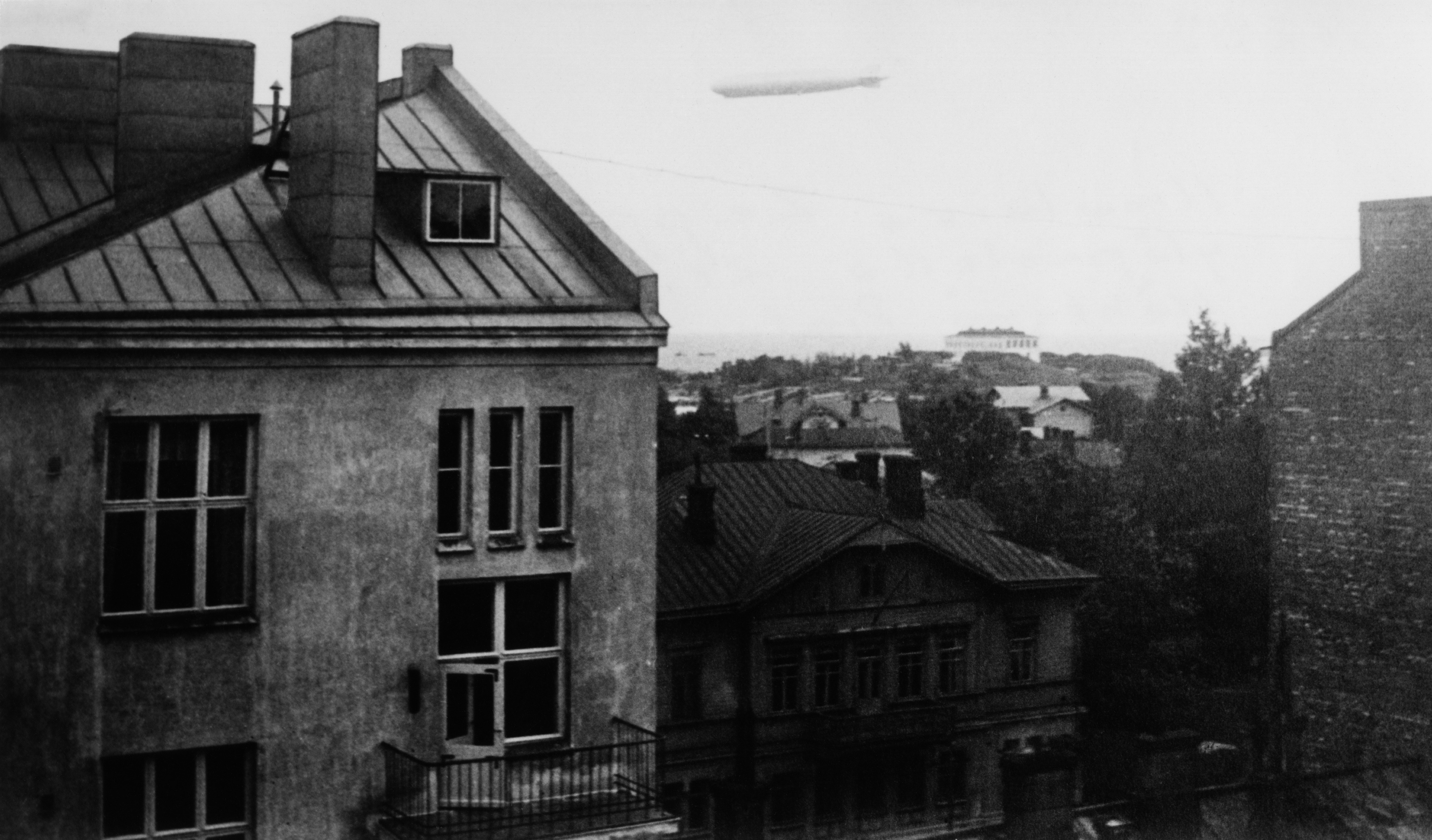 Ilmalaiva Graf Zeppelin Helsingissä. Kuvattu Pietarinkatu 2 C 30:n ikkunasta kaakkoon, taustalla oleva vaalea rakennus on Puolustuslaitoksen tutkimuskeskuksen kemian laboratorio Harakan saarella.