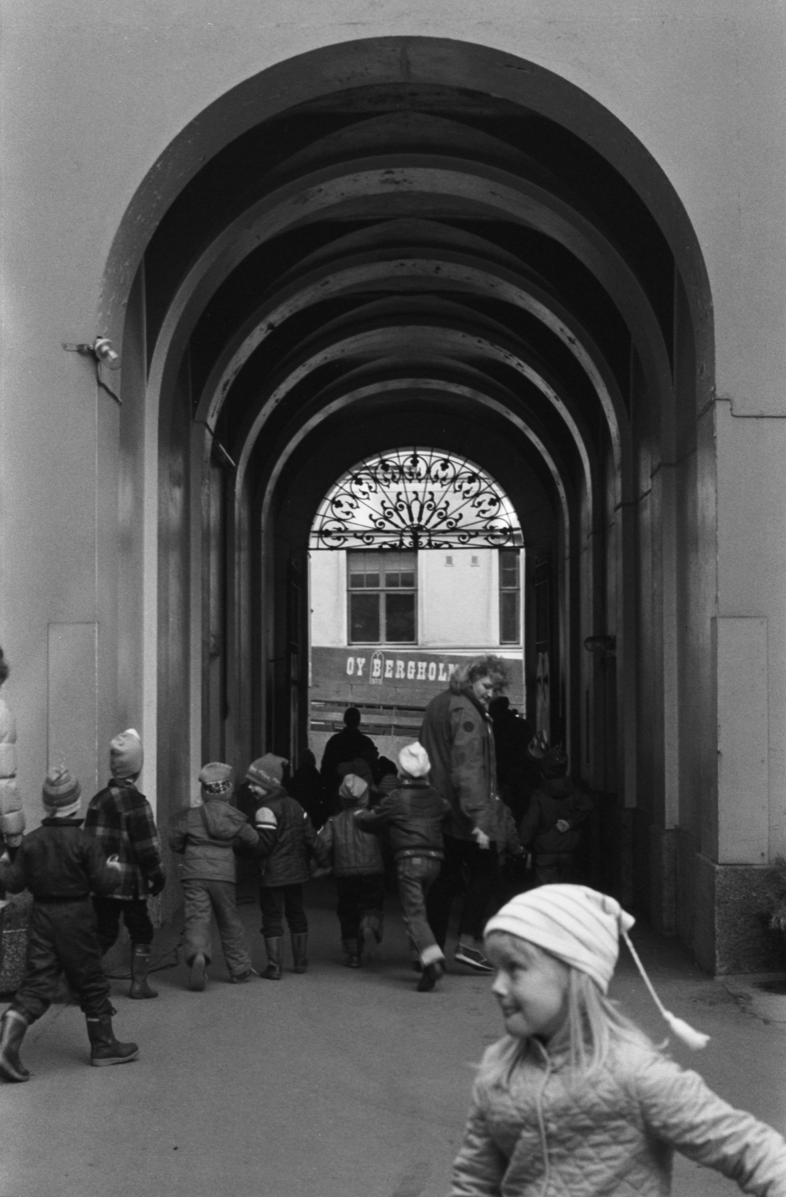 Vironkatu 7. Vironniemen päiväkodin lapsia opettajineen Vironkatu 7:n pihalla ja porttikäytävässä. Tutustumiskäynti porrashuoneremonttiin on ohi ja vuorossa on paluu päiväkotiin.
