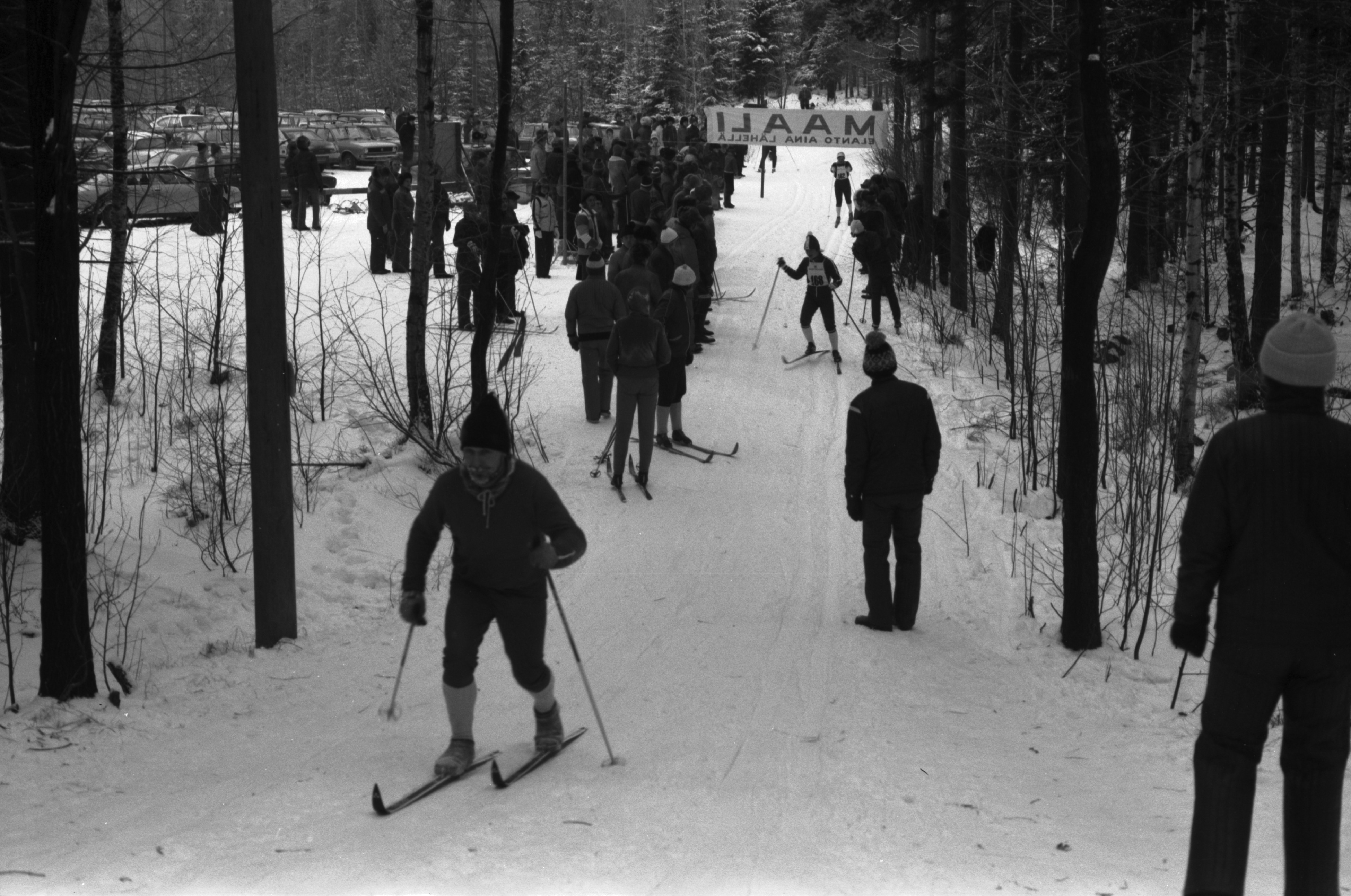 Pirkkolan urheilupuisto. Hiihtokilpailut Pirkkolan urheilupuistossa. Ihmisiä seuraamassa maaliin tulevia hiihtäjiä.