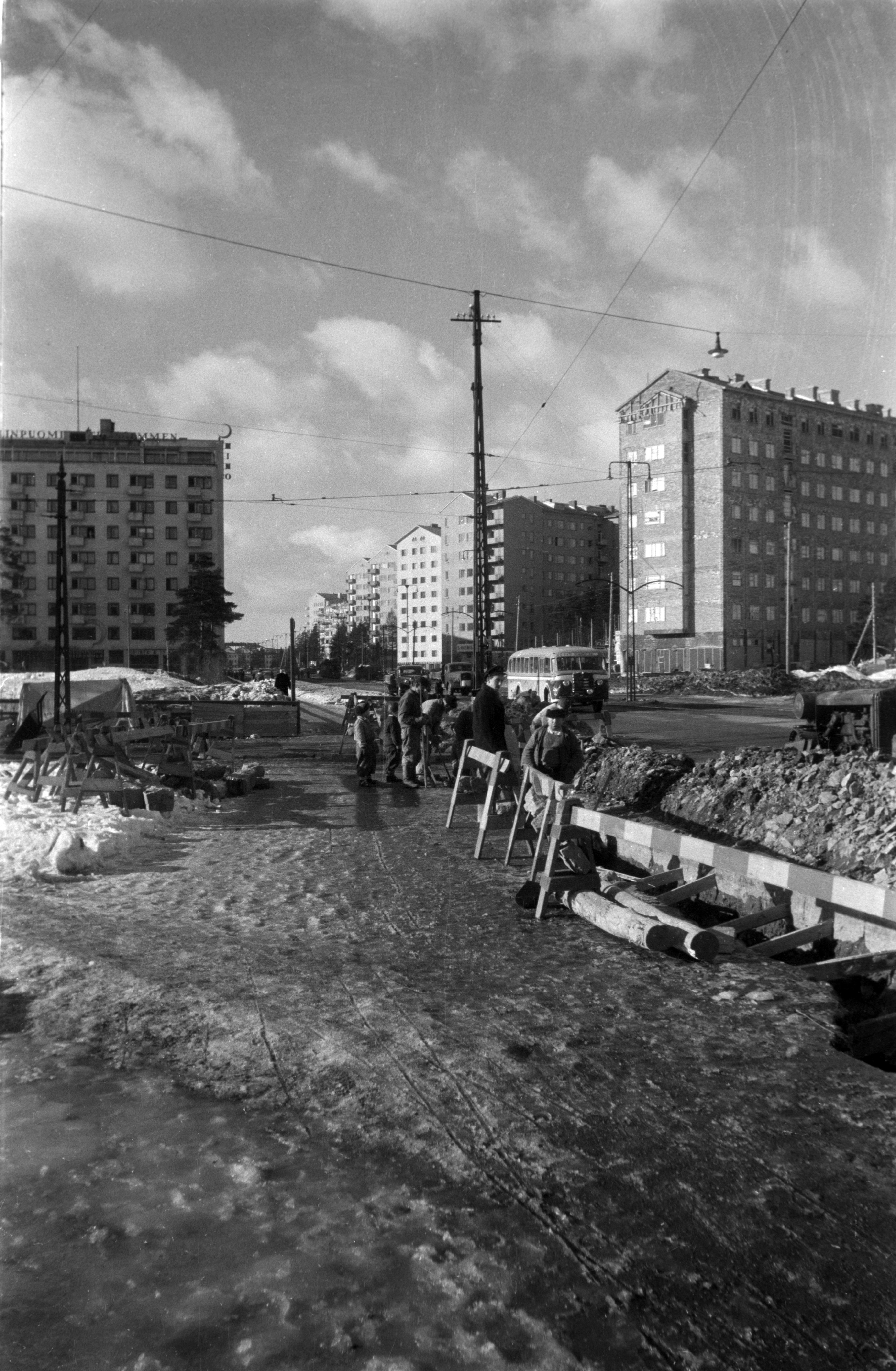 Rakennustöitä Mannerheimintiellä Tullinpuomin kohdalla. Mannerheimintie 116 huoltoasema rakenteilla. Taustalla Mannerheimintie 118, ja 75 - 83, joista osa rakenteilla.