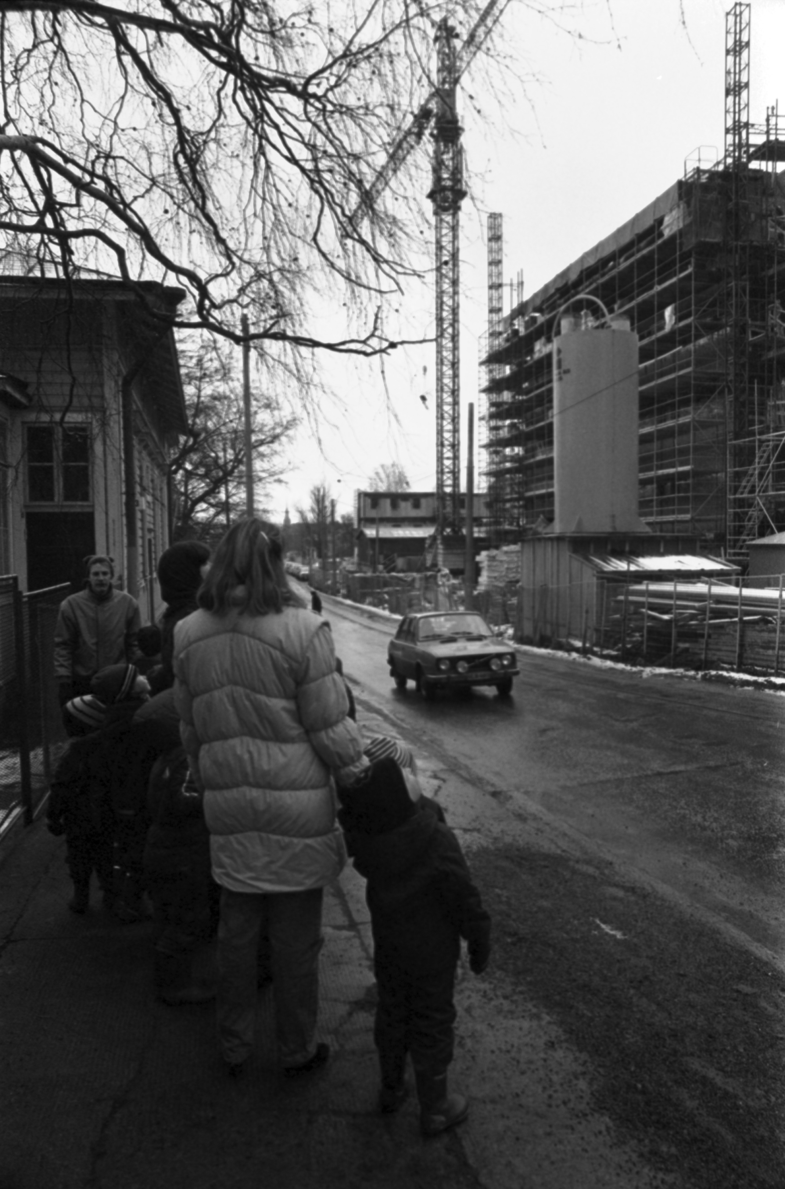 Wallininkatu 2. Vironniemen päiväkodin lapsia ja aikuisia Wallininkadulla matkalla tutustumaan oikealla olevaan Suomen Kaupunkiliiton toimitalon (Kuntatalon) rakennustyömaahan. Vasemmalla Wallininkatu 3:n (1:n) puutalo.