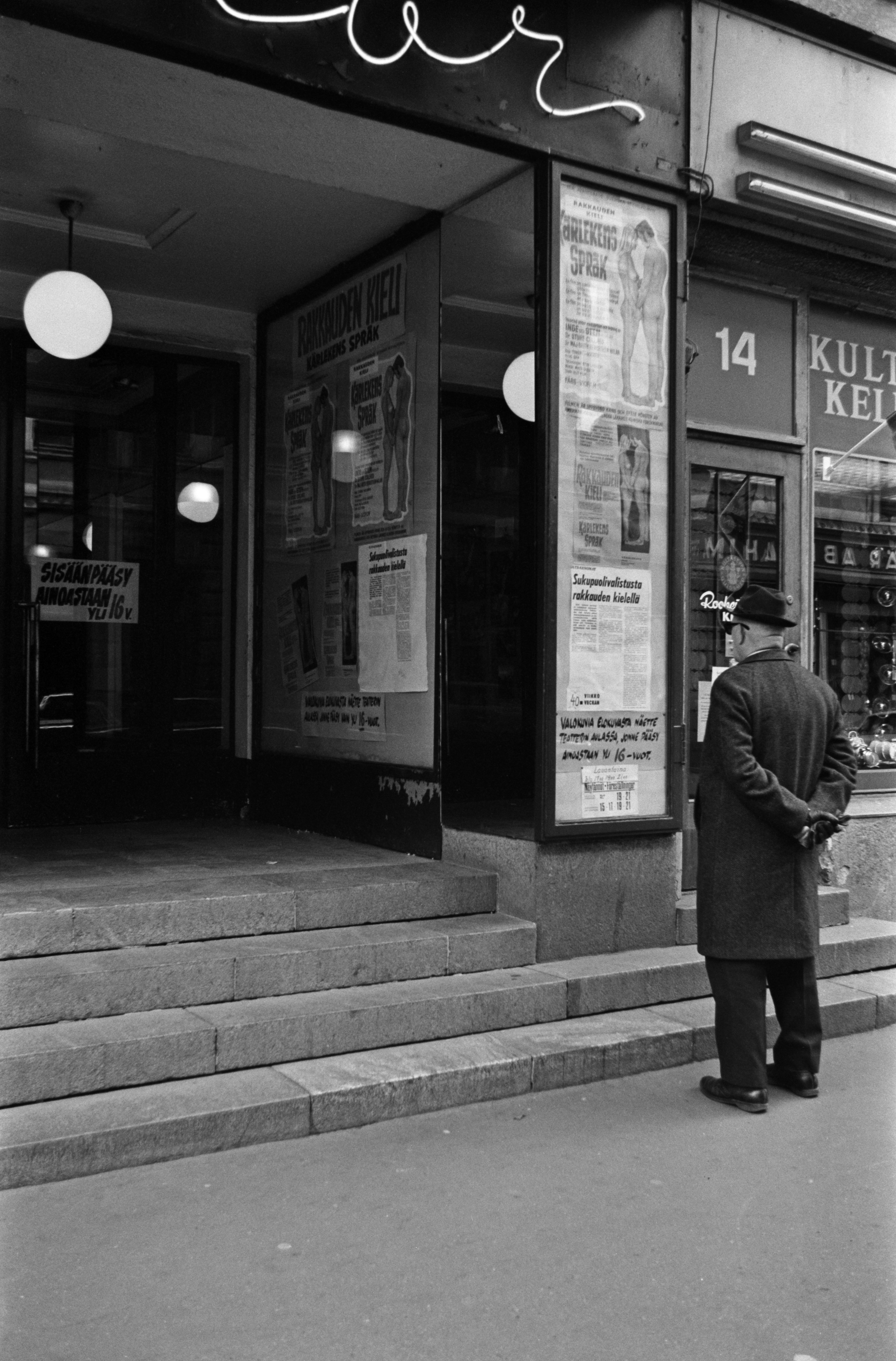 Iso Roobertinkatu 14. Mies katselemassa Rakkauden kieli -elokuvan mainoksia elokuvateatteri Astorin edustalla Iso Roobertinkadulla.