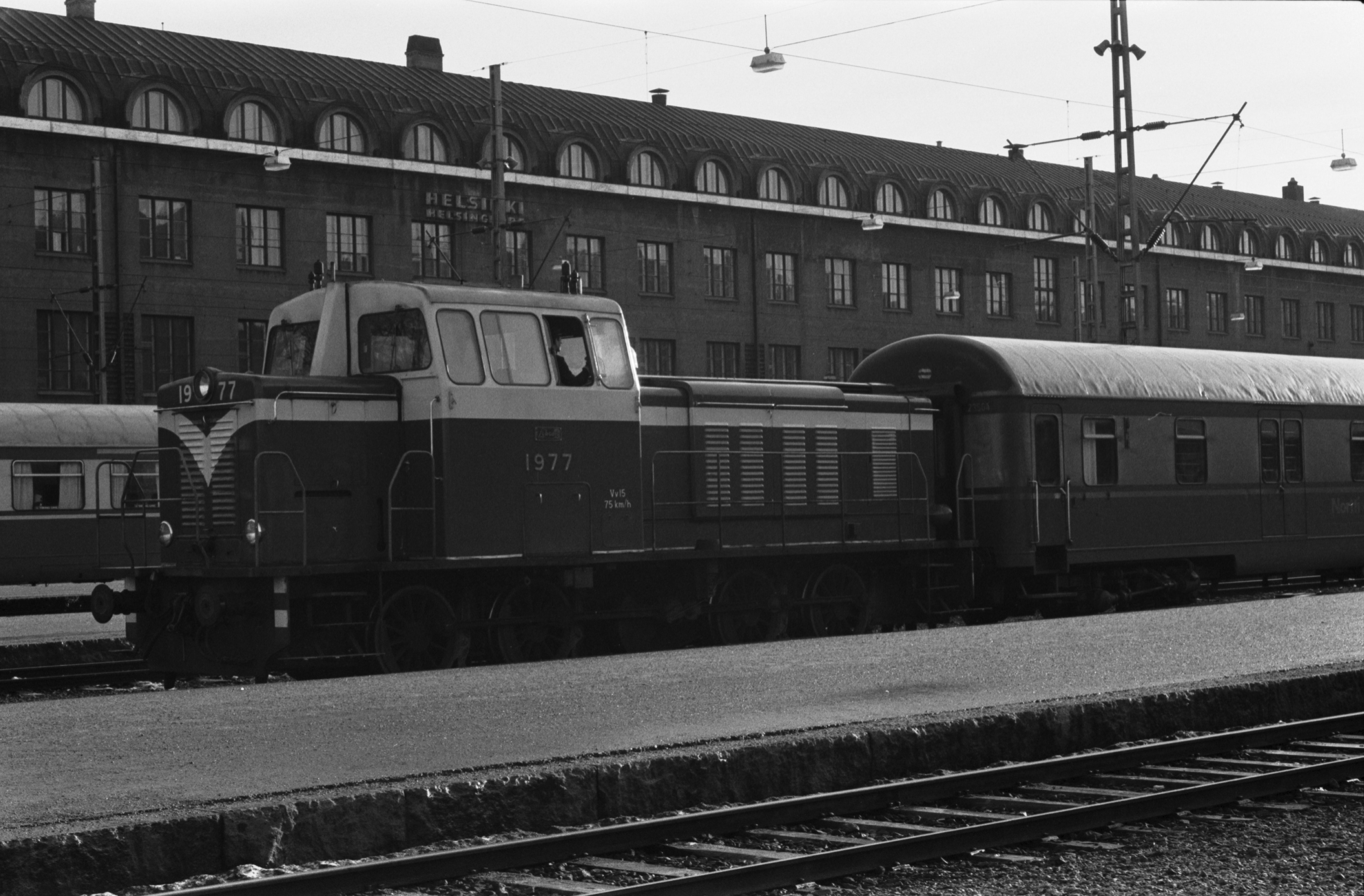 Helsingin rautatieasema. Junia Helsingin rautatieasemalla. Edessä Vv15-sarjan dieselveturi 1977.