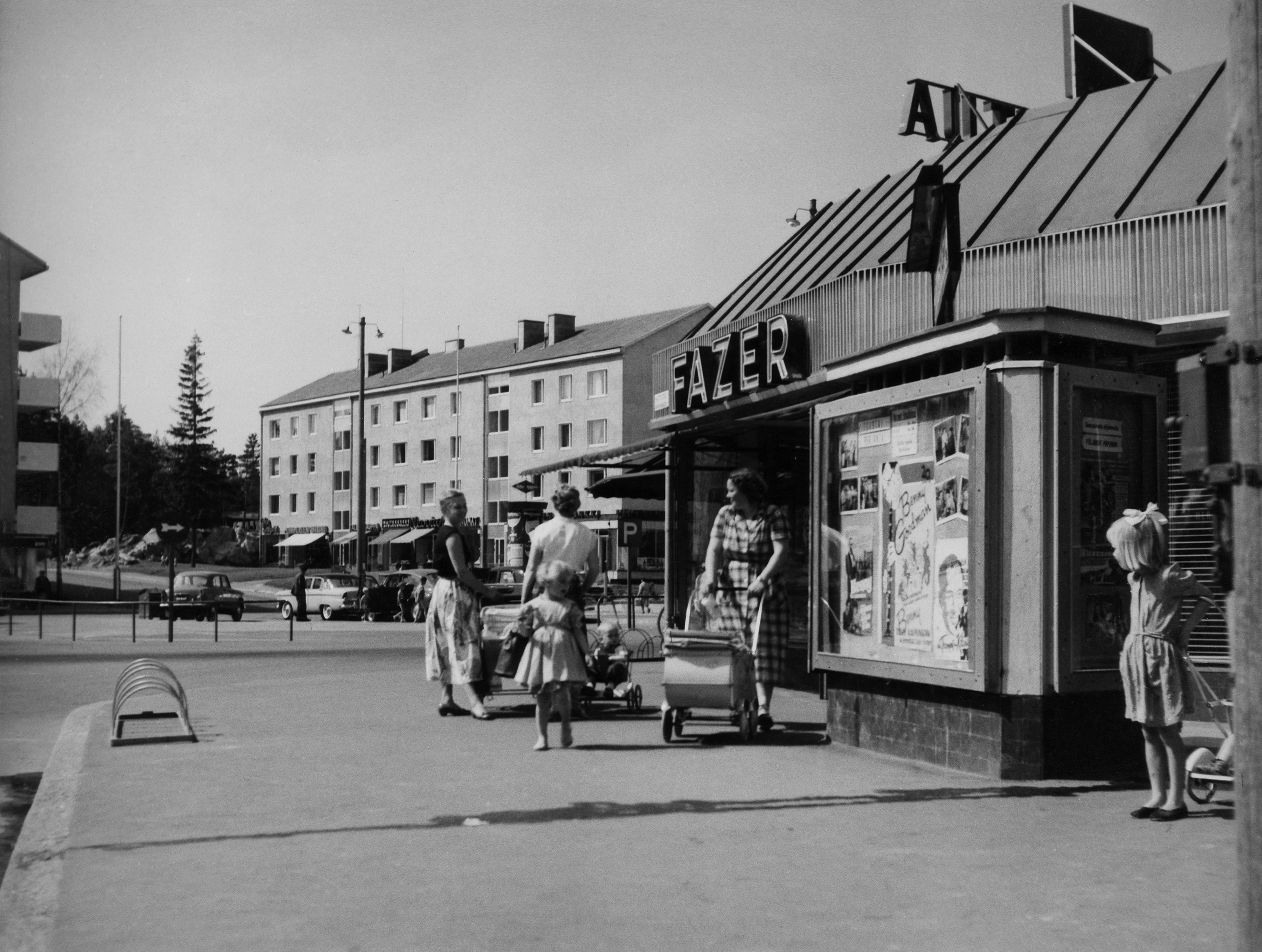 Länsi-Herttoniemi. Eränkävijäntori. Oik. Kettutie 2. Taustalla Hiihtomäentie 36. Osoitteessa Kettutie 2 toimi elokuvateatteri Herttua (n.1955 - 20.06.1965.) ja Fazerin kahvila.