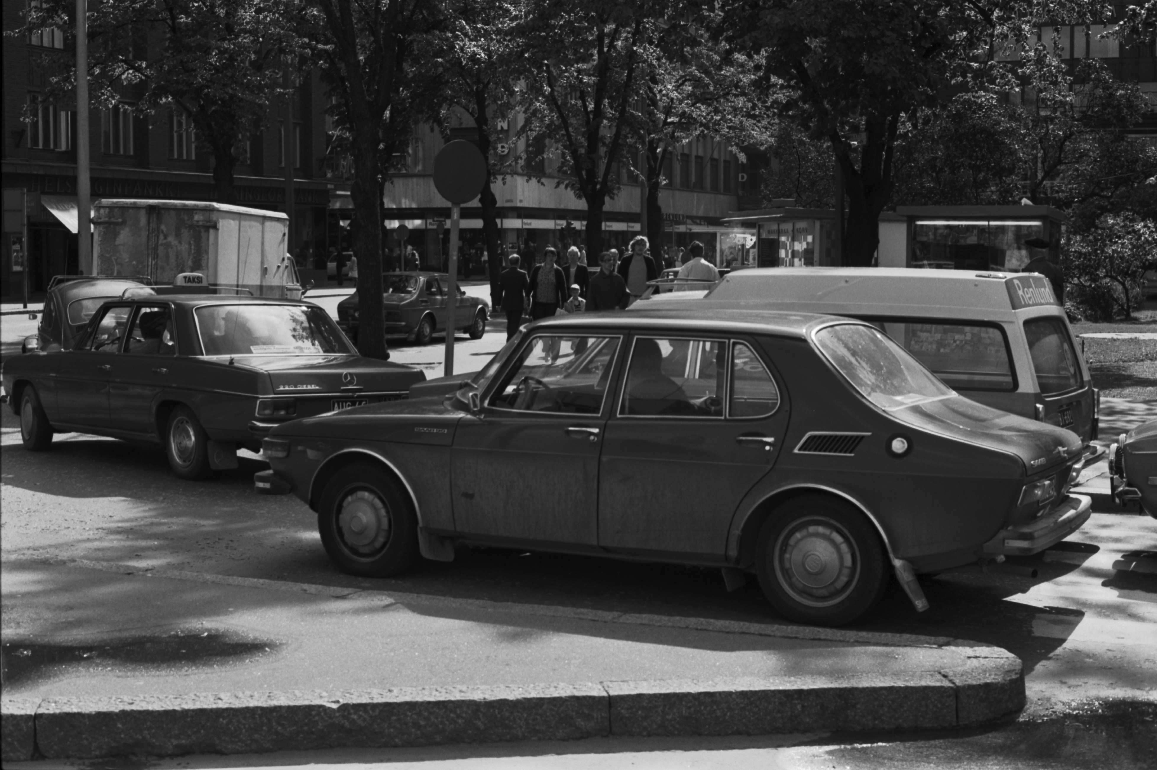 Mikonkatu. Autoja kääntymässä Kaivokadulta Mikonkadulle. Näkymä Kaivokadulta Hallituskadun (nyk. Yliopistonkadun) kulmaan. Edessä Saab 99, jonka takana Renlundin rautakaupan Volvo 145 Express -pakettiauto ja edessä Mercedes-Benz -taksi.