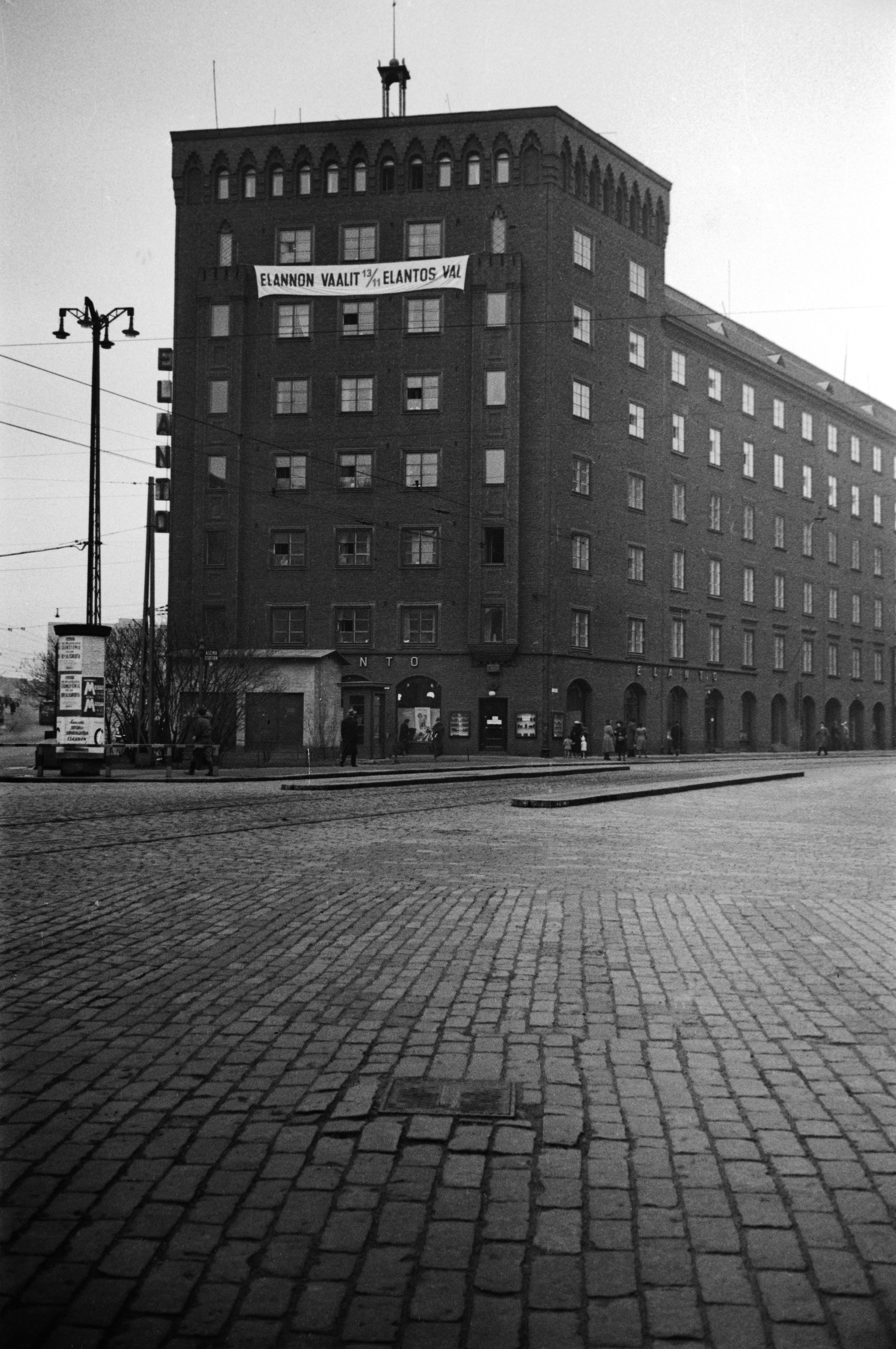 Runeberginkatu 28. - Caloniuksenkatu 9. Rakennuksen seinässä Elannon vaalien mainos.