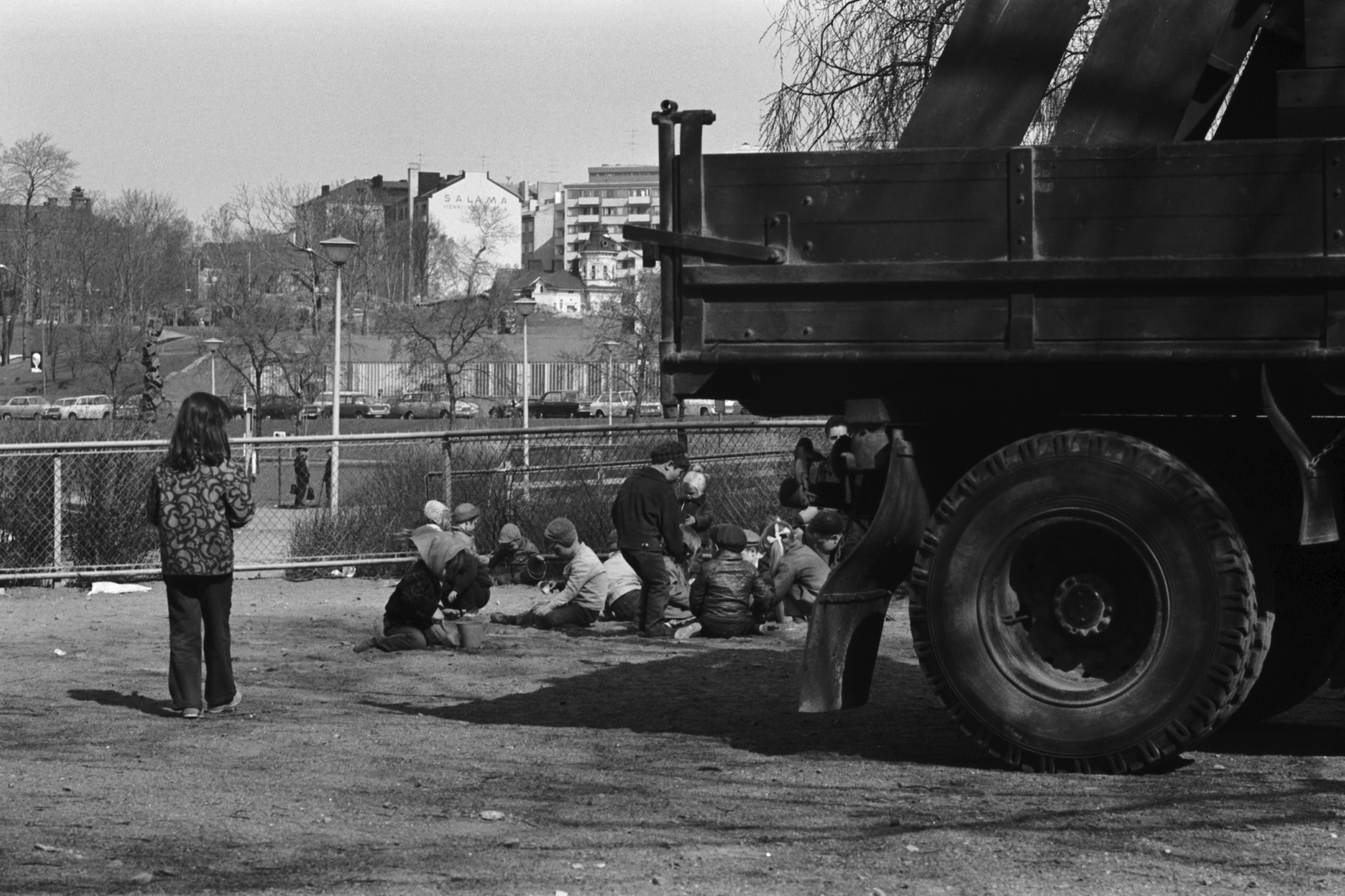 Tokoinranta. Lapsia leikkimässä Eläintarhantien ja Säästöpankinrannan kulmauksessa olevassa puistossa. Etualalla iso kuorma-auto, jonka lavalla hiekkalaatikoita.