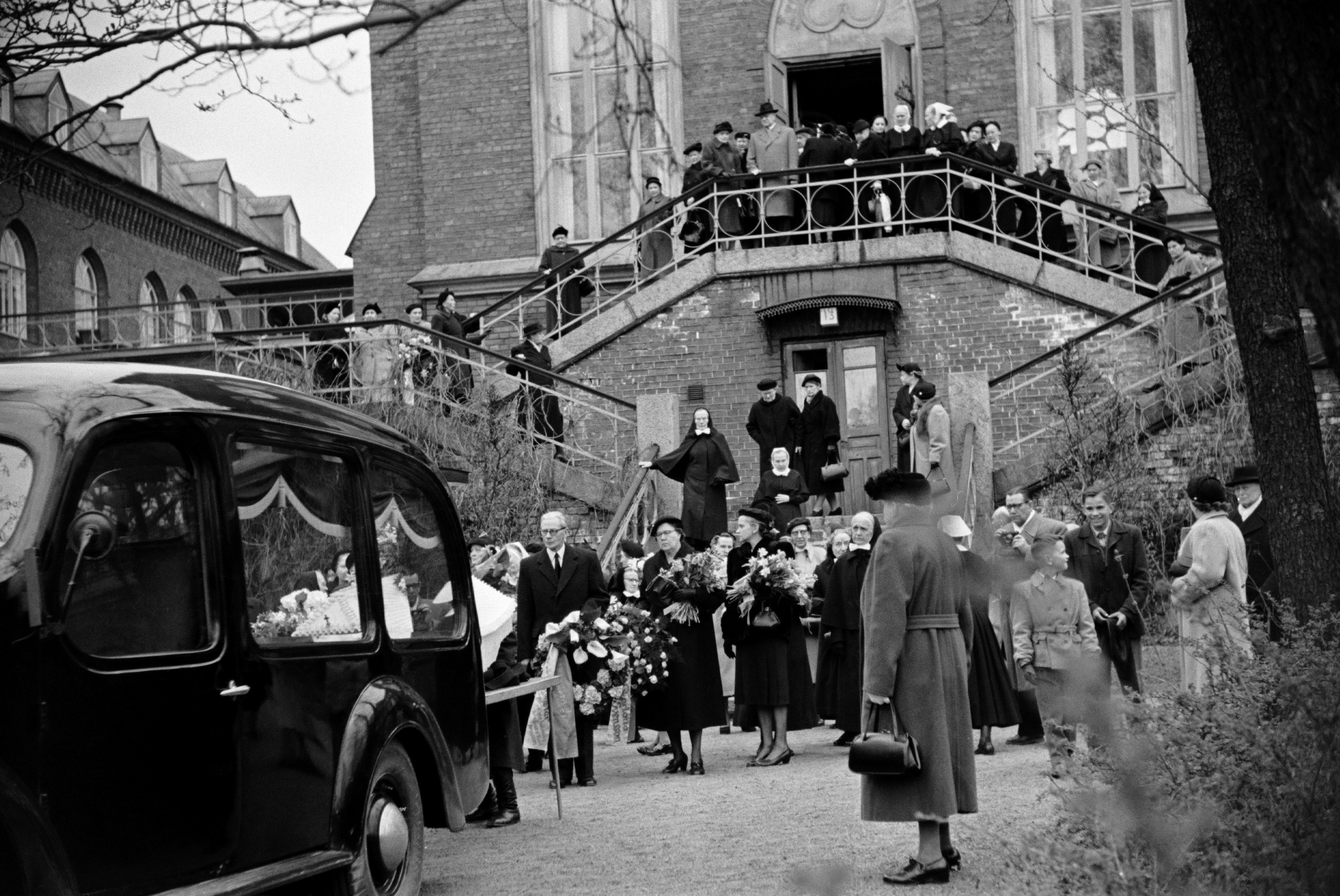 Helsingin Diakonissalaitoksen kirkko, Ester Svenssonin hautajaiset. Omaiset laskevat kukkia ja seppeleitä autoon nostetulle arkulle.
