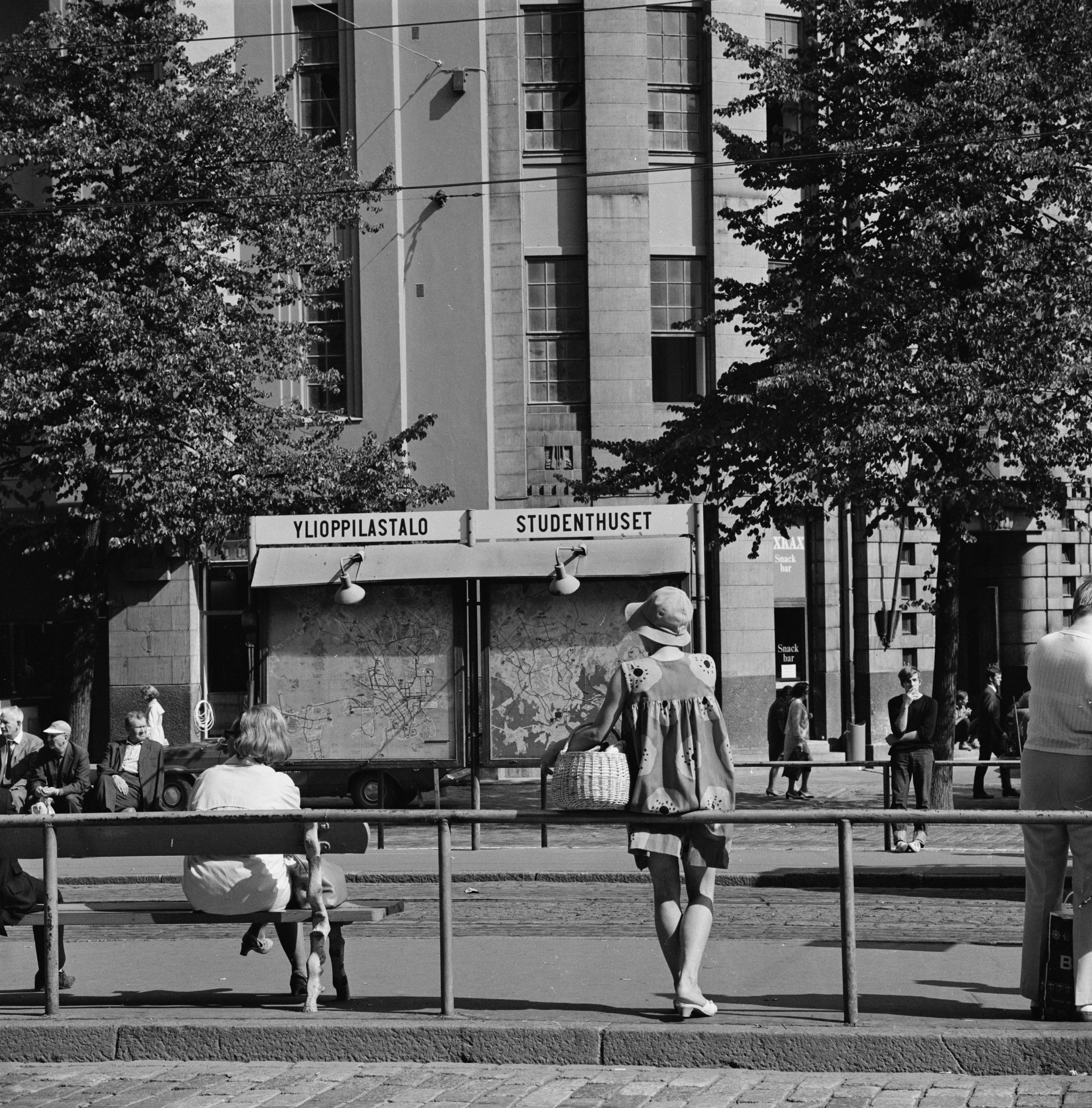 Ihmisiä raitiovaunupysäkillä Mannerheimintiellä Uuden ylioppilastalon edustalla.