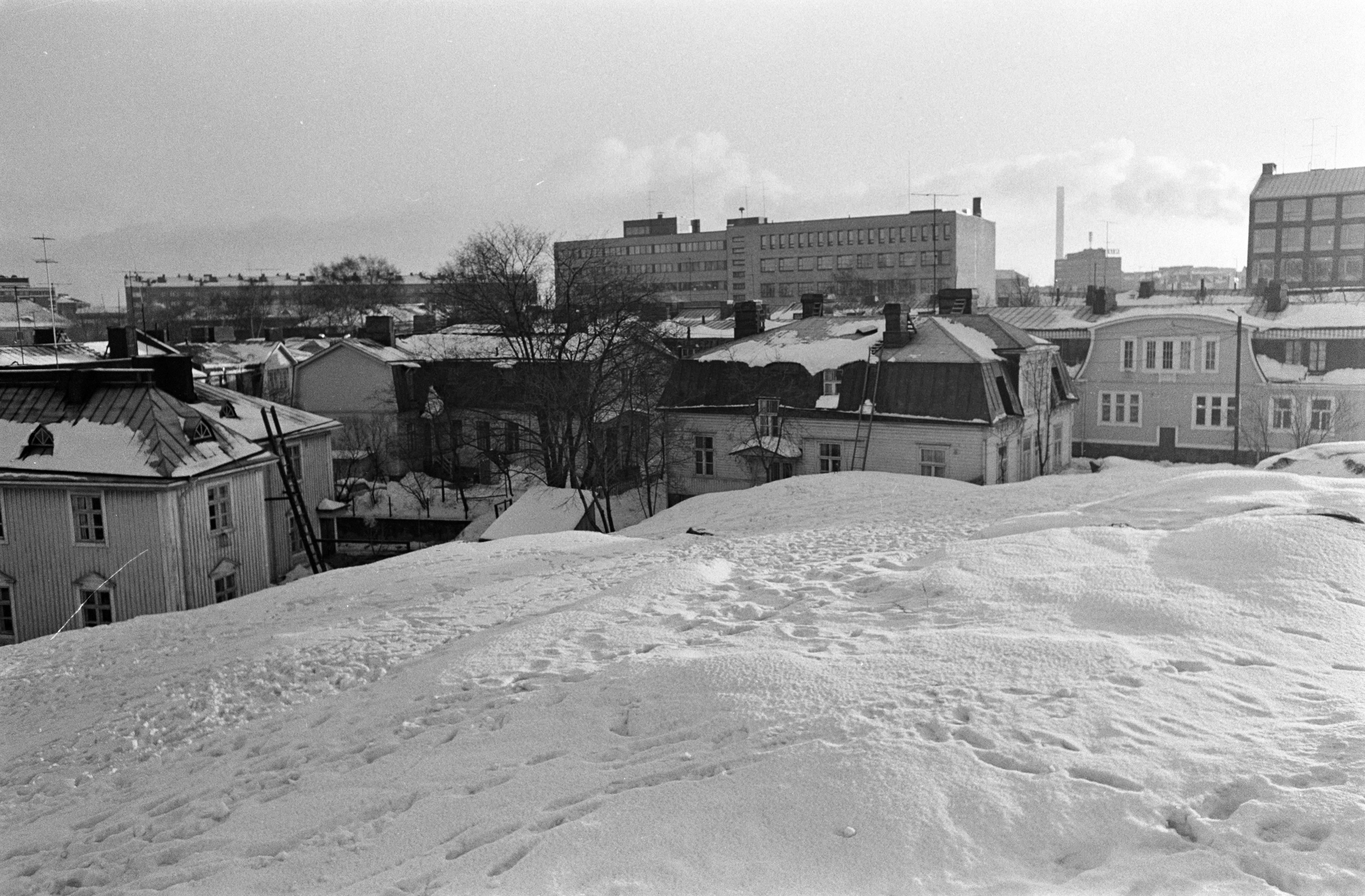 Näkymä Keuruunpuiston lumisilta kallioilta Puu-Vallilasta Vallilantien, Päijänteentien ja Teollisuuskadun suuntaan.