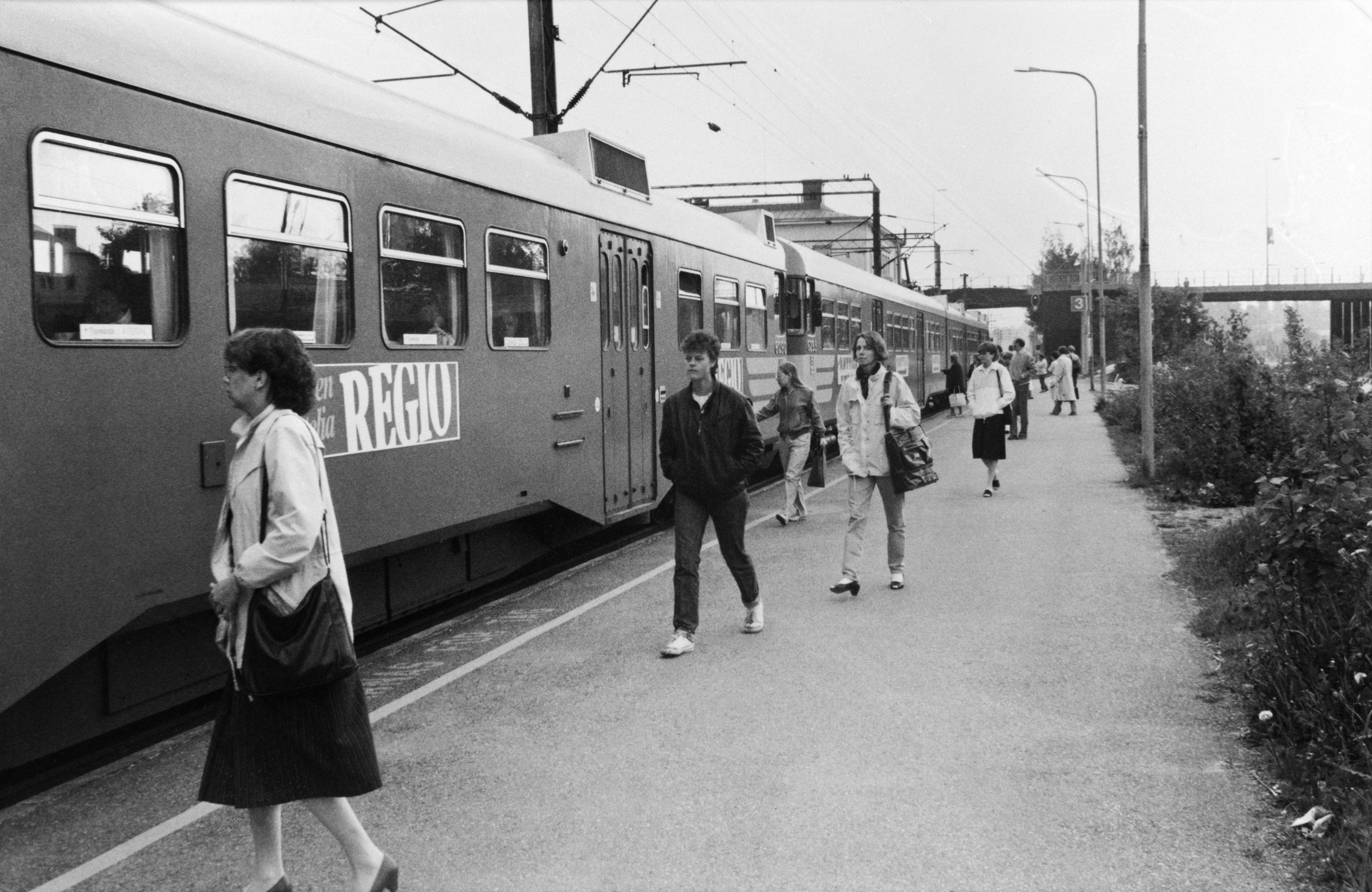 Lähiliikenteen juna ja matkustajia Malmin asemalla.
