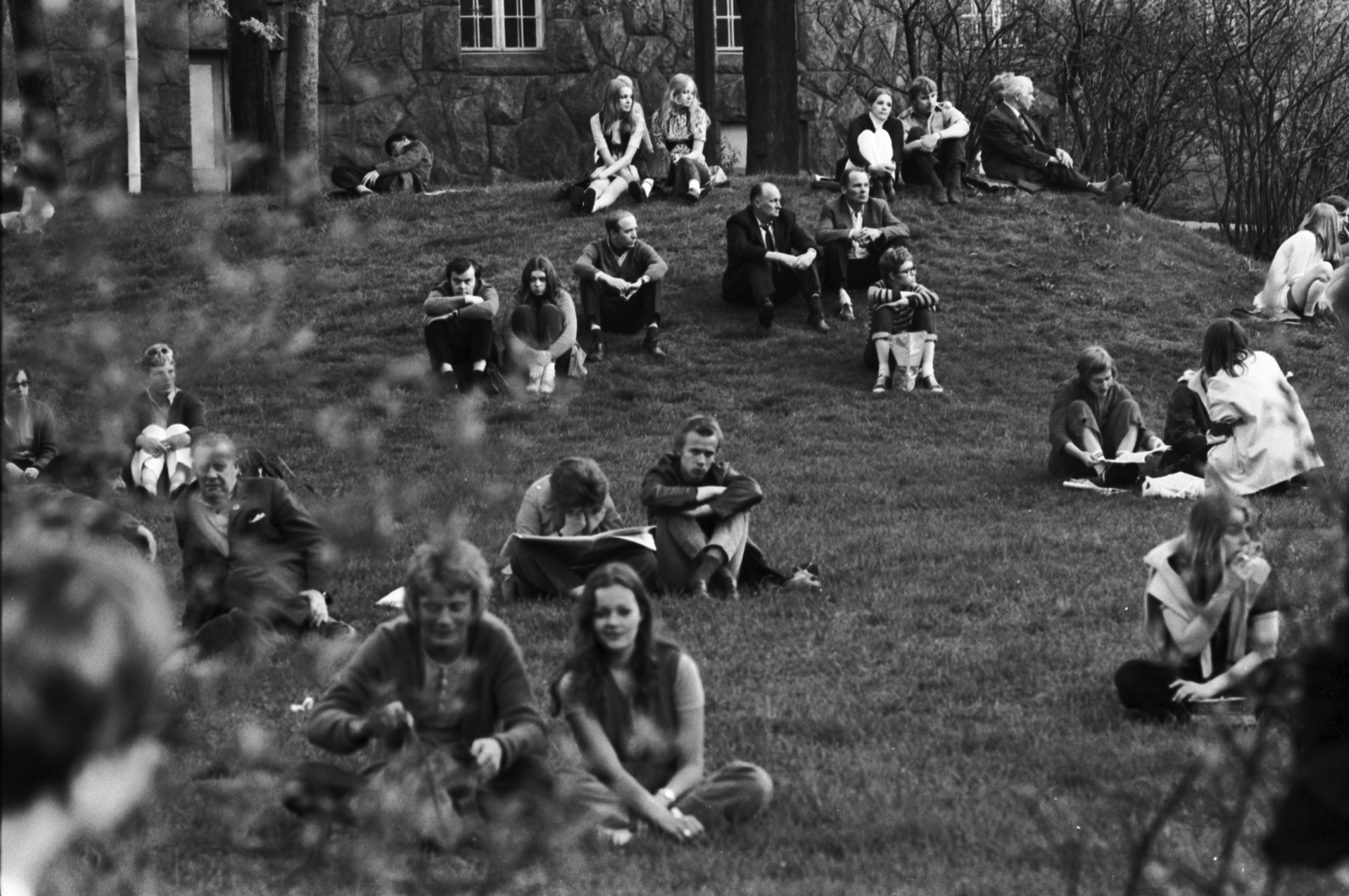 Kaisaniemenpuisto. Rinteellä istuvia ihmisiä Vietnamin sodan vastaisessa mielenosoituksessa Kaisaniemenpuistossa.