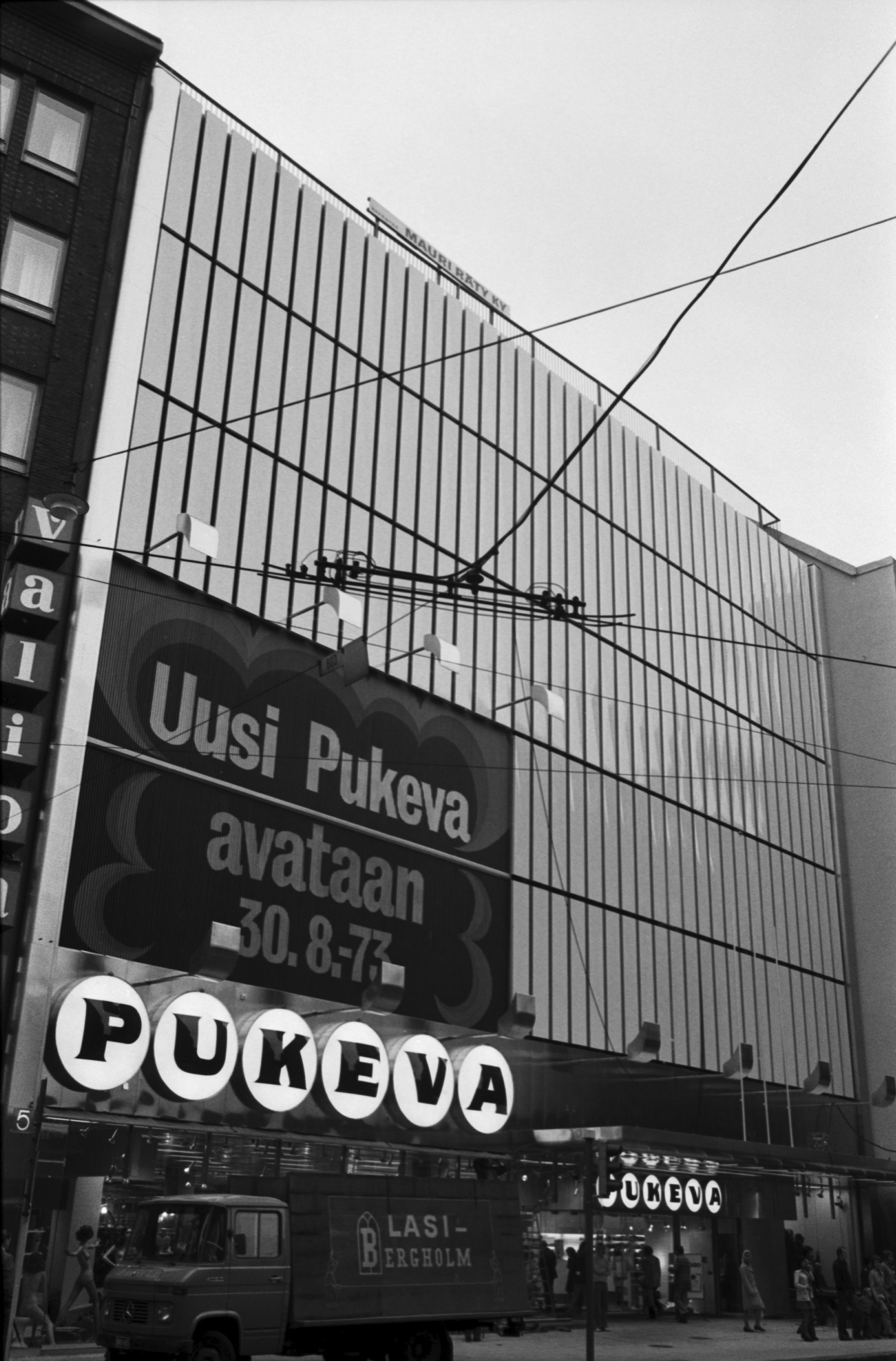 Kaisaniemenkatu 5. Pukevan tavaratalo laajennusosan valmistuttua. Talon seinässä teksti: Uusi Pukeva avataan 30.8.1973.