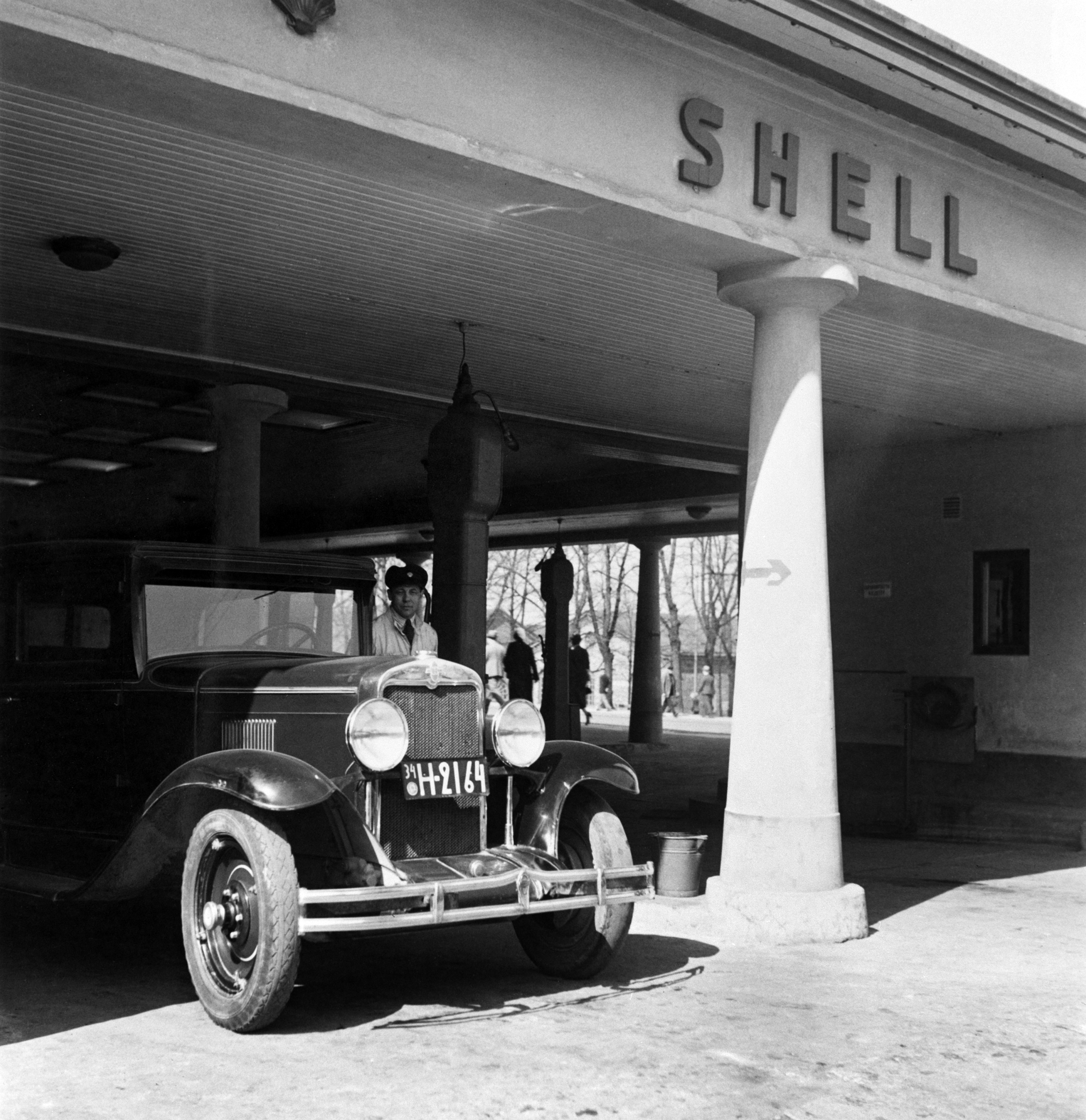 Oy Shell Ab:n huoltoasema, Turun kasarmi, Simonkatu 1 - Heikinkatu 28 (Mannerheimintie 22-24). Rakennettu 1928, purettu 1934. Auto huoltamon katoksen alla.