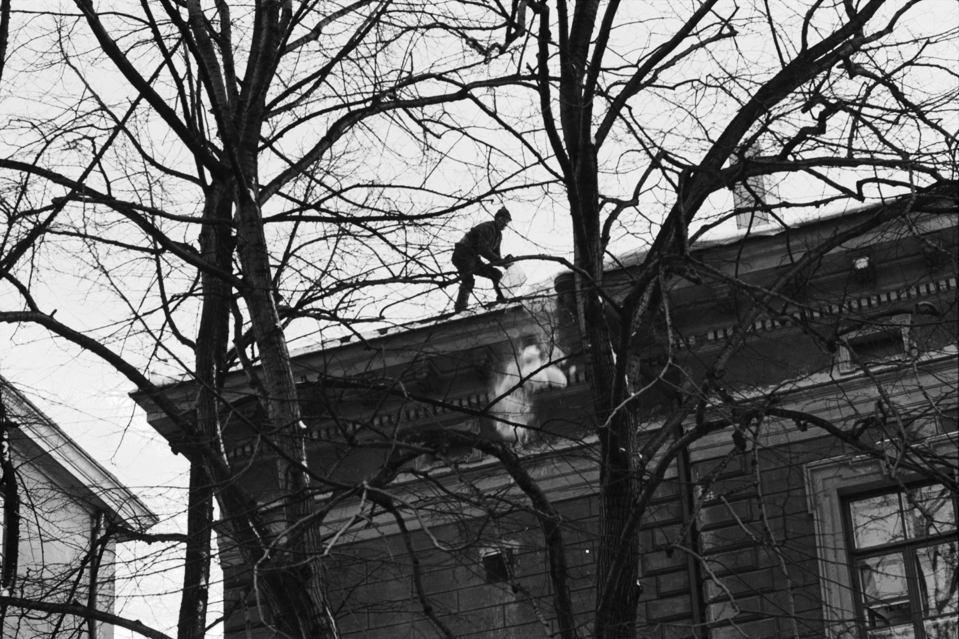 Kruununhaka, Liisankatu 8. Mies pudottamassa lunta Maatilahallituksen talon katolla Liisankadulla Mariankadun kulmassa.