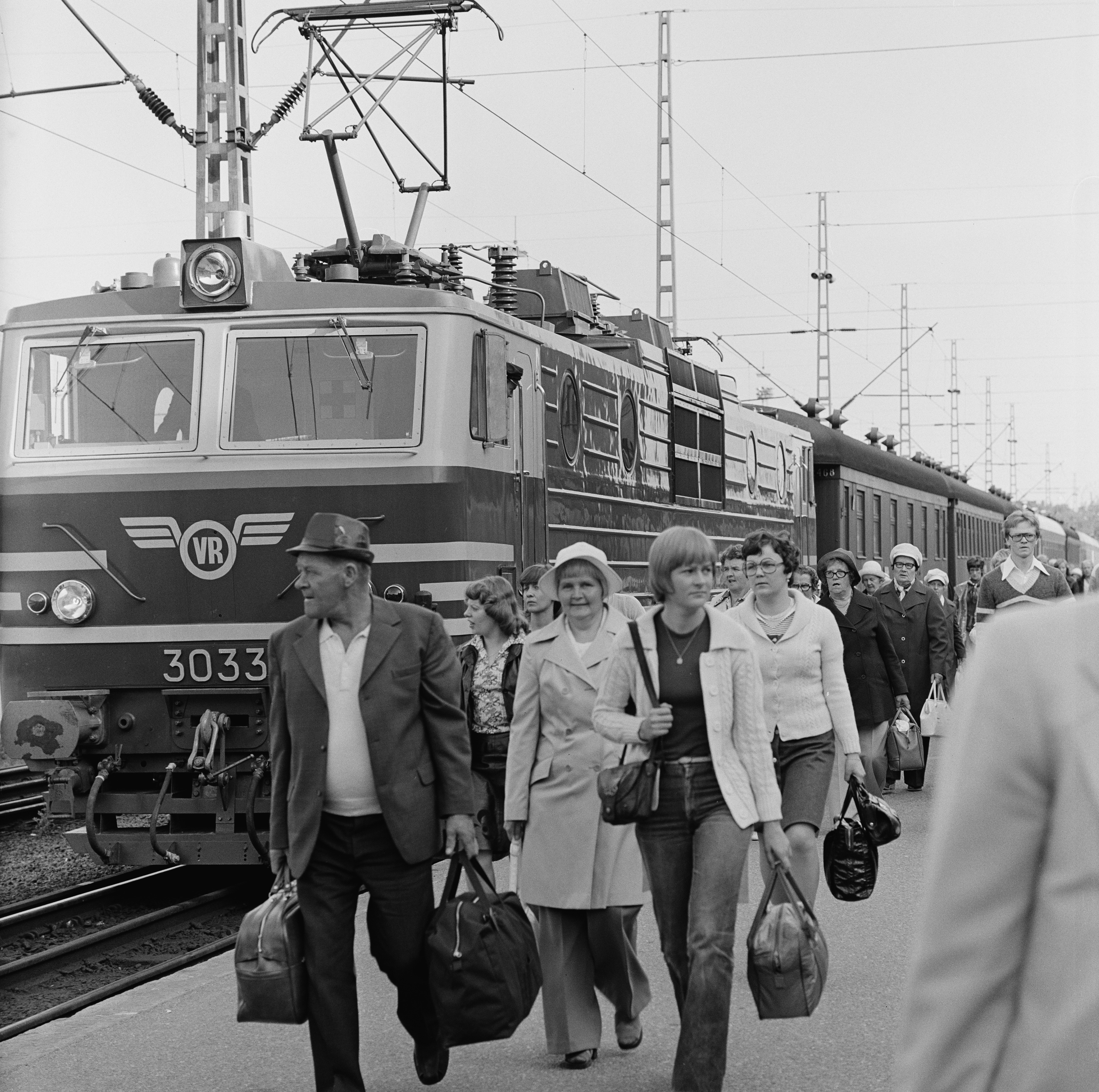 Matkustajia ja juna Helsingin rautatieasemalla.