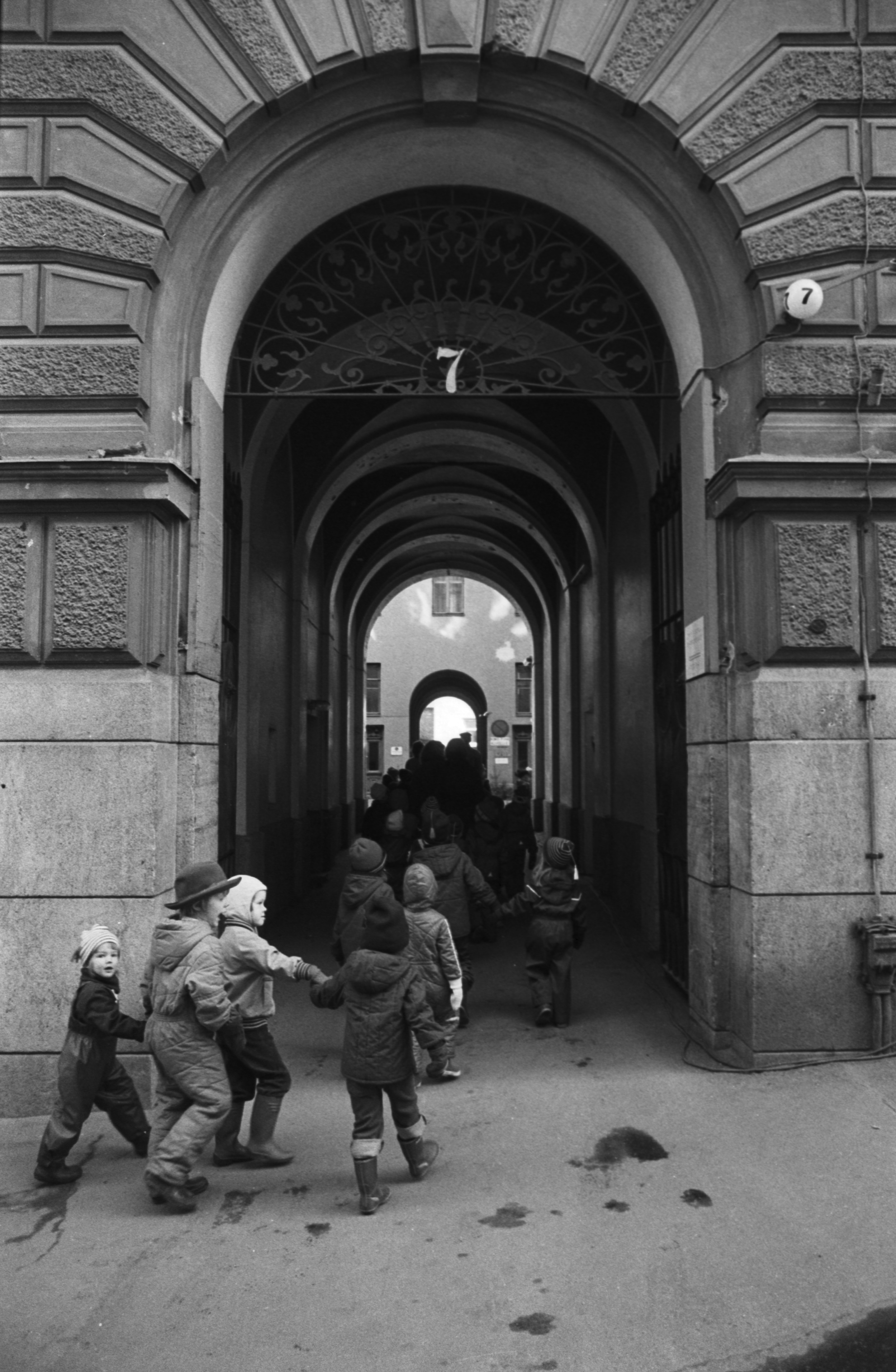 Vironkatu 7. Vironniemen päiväkodin lapsia Vironkatu 7:n porttikongissa menossa tutustumaan talon porrashuoneremonttiin.