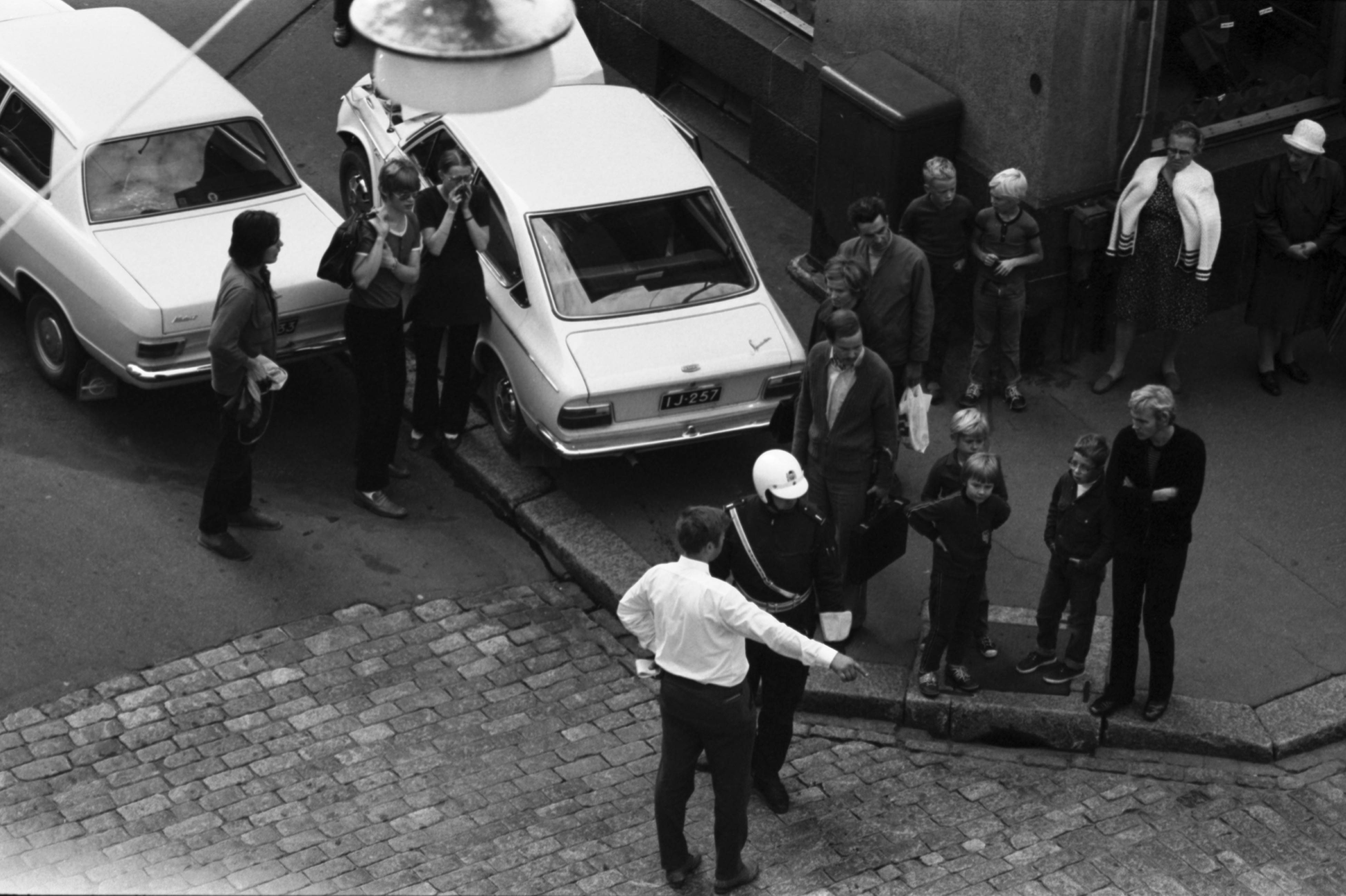 Meritullinkatu 24. Poliisi selvittelemässä autokolaria ihmisten seuratessa tilannetta Meritullinkadun ja Liisankadun risteyksessä. Kuvattu Liisankatu 7:n neljännen kerroksen ikkunasta.