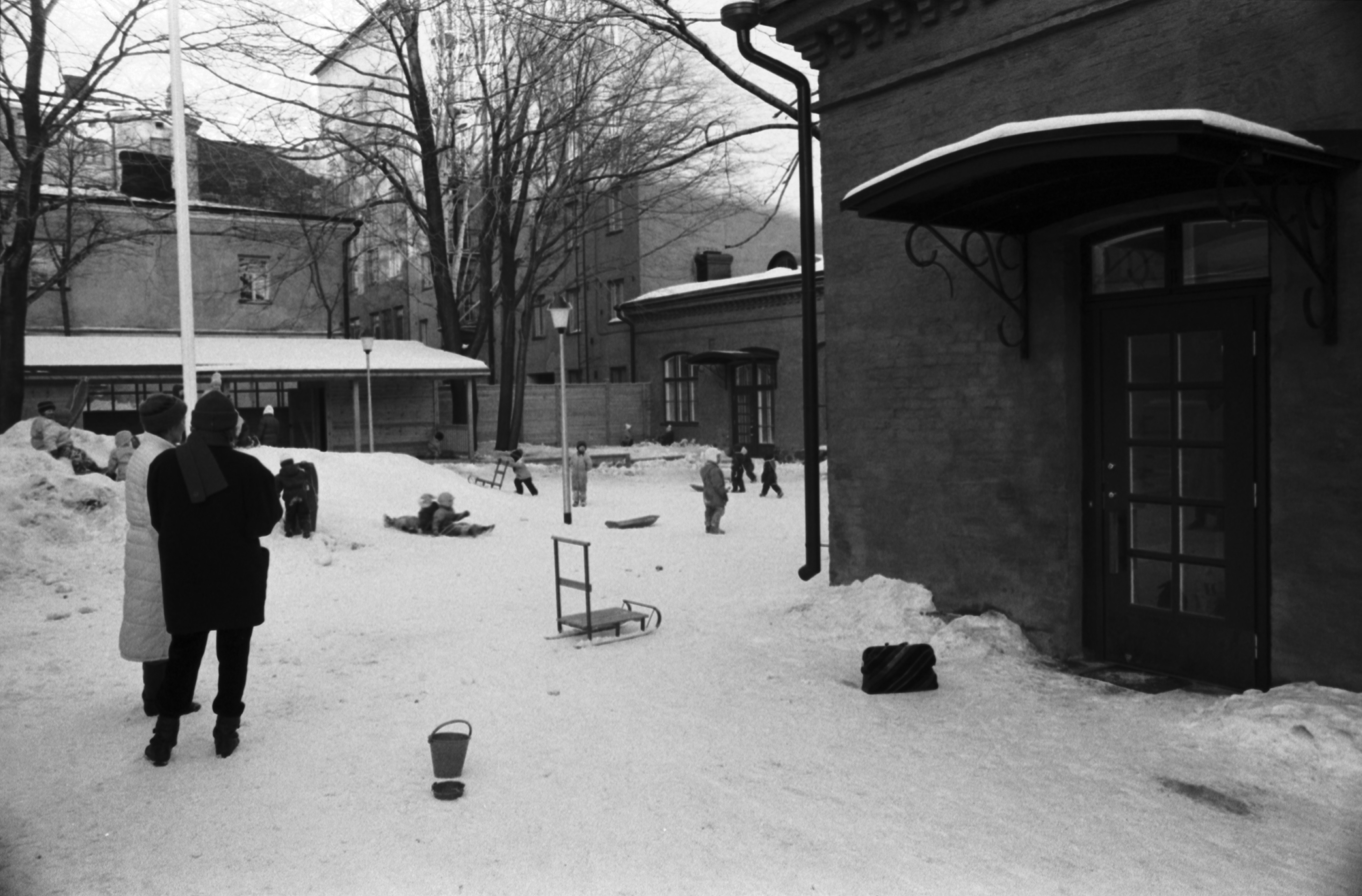 Aleksanterinkatu 1. Talvinen näkymä päiväkoti Aleksin lumisesta pihapiiristä.