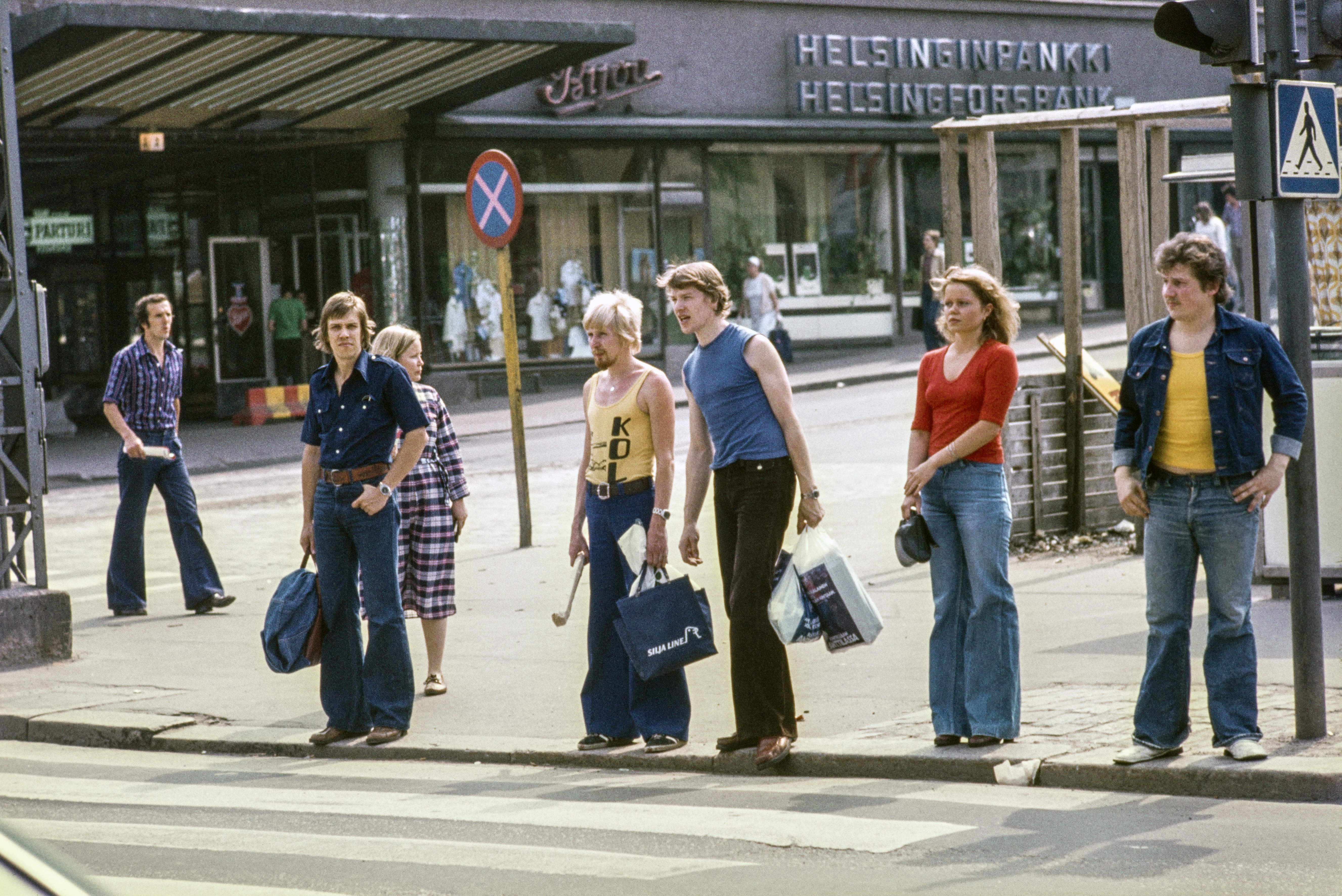 Jalankulkijoita odottamassa suojatien ylitystä Mannerheimintiellä, Lasipalatsin kulmalla. Taustalla Simonkadun alkupää ja Forumin v. 1952 rakennettu liikekeskus.