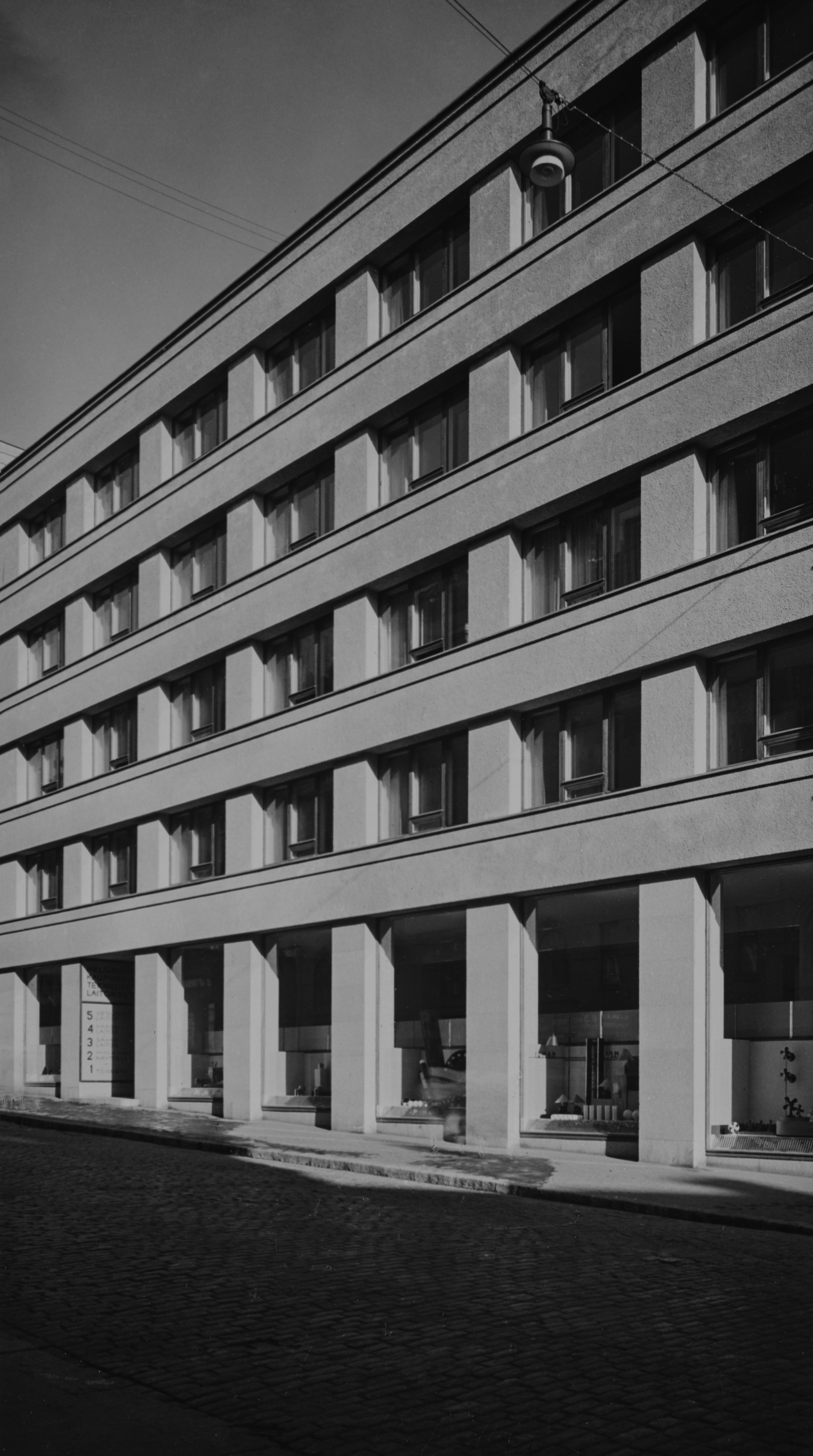 Teknillisten laitosten hallintorakennus, Pieni Roobertinkatu 1-3. Julkisivukuvassa näkyy Helsingissä 1930-luvun alussa käyttöön otettu ripustettu katuvalo ns. Y-valaisin, joita on edelleen käytössä.