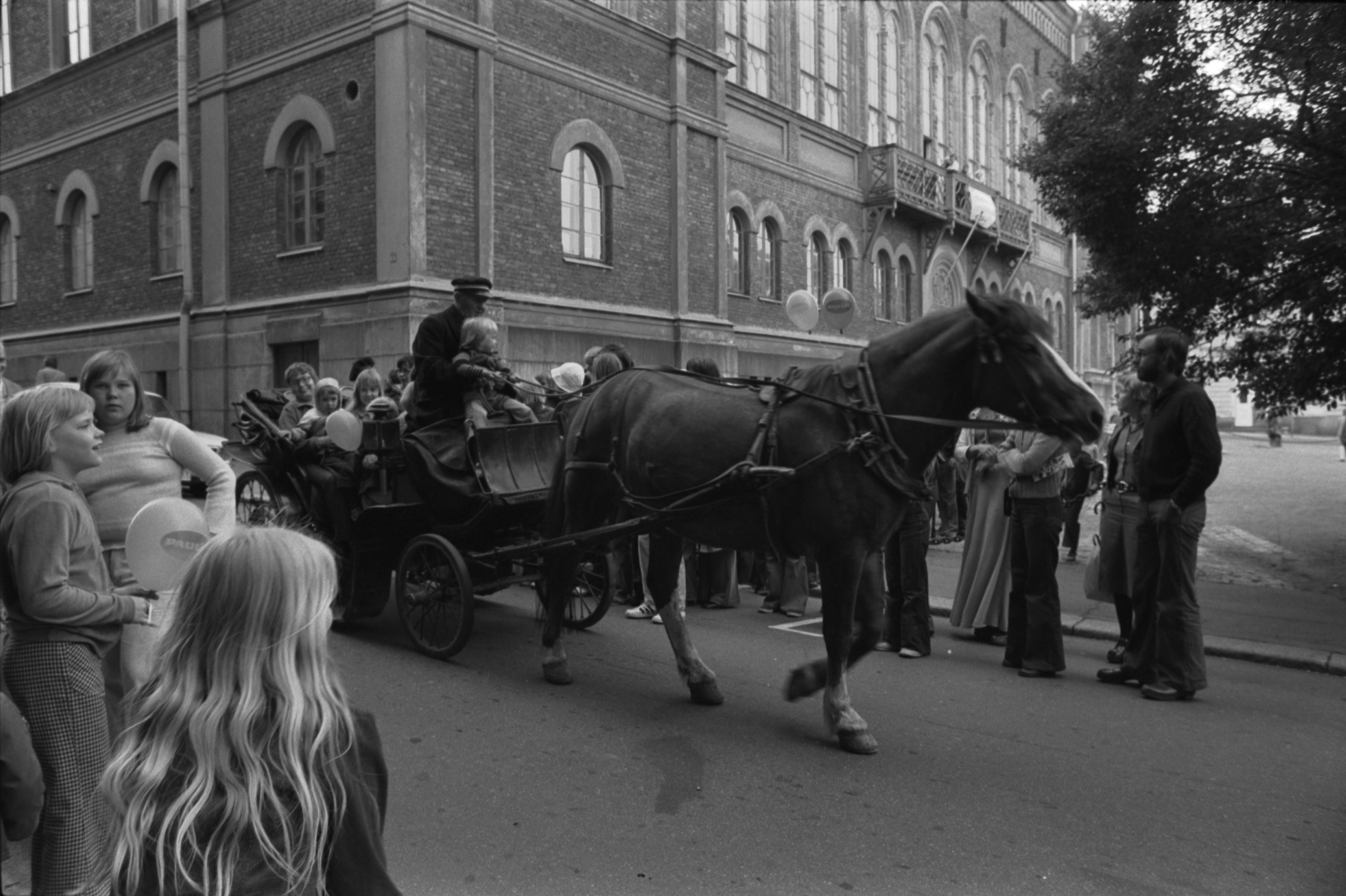 Ritarikatu 1. Ihmisiä vossikan ympärillä Ritarihuoneen kulmalla odottamassa vuoroaan ajelulle Kruununhaan asukasyhdistyksen järjestämässä juhlassa Helsinki-päivänä 12.6.1975.