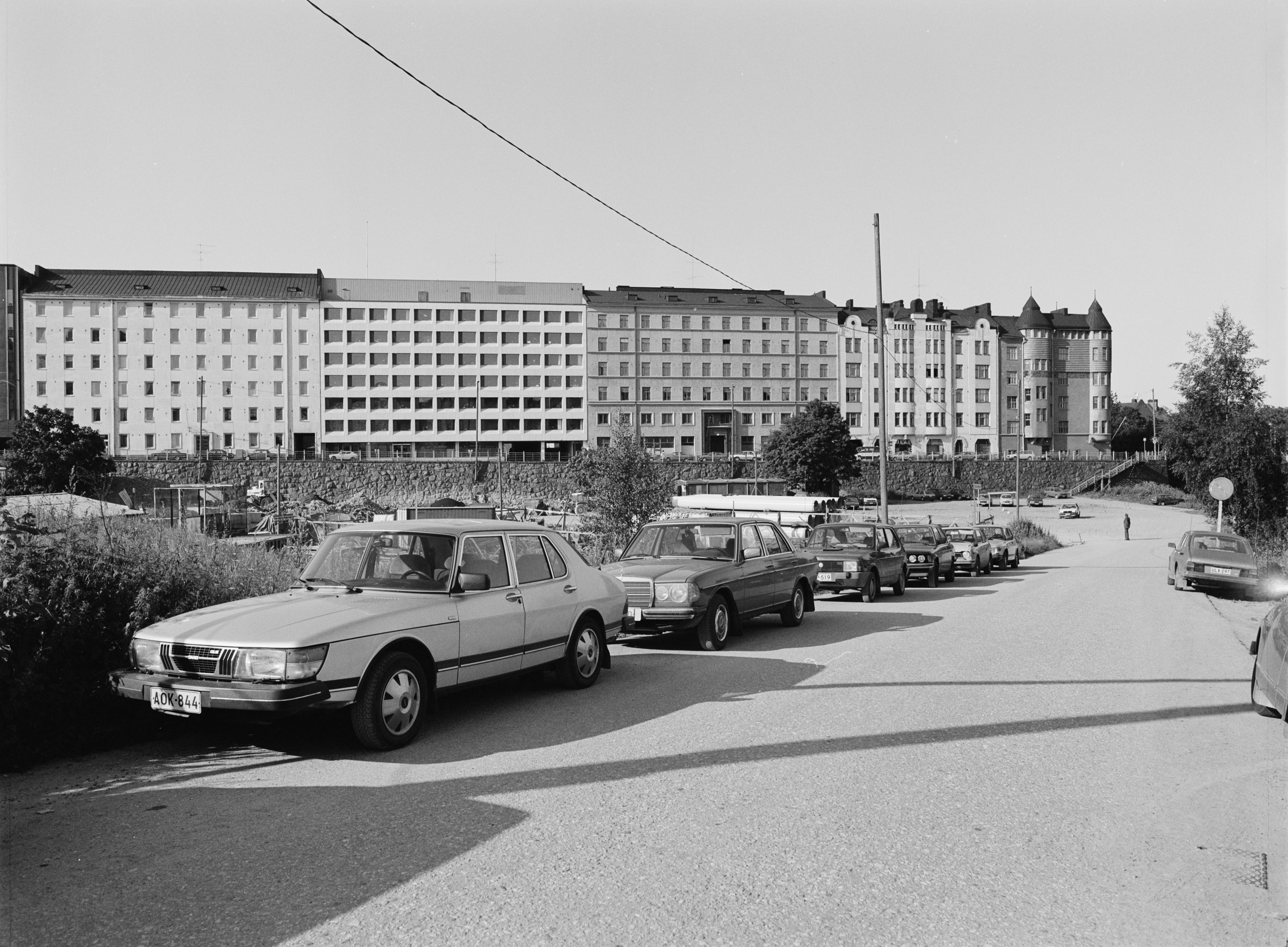 Autojen pysäköintoalue Kampin kolmiossa, Runeberginkadun ja Malminkadun välissä.  Taustalla Malminkatu 32, 34, 36, 38, 40.
