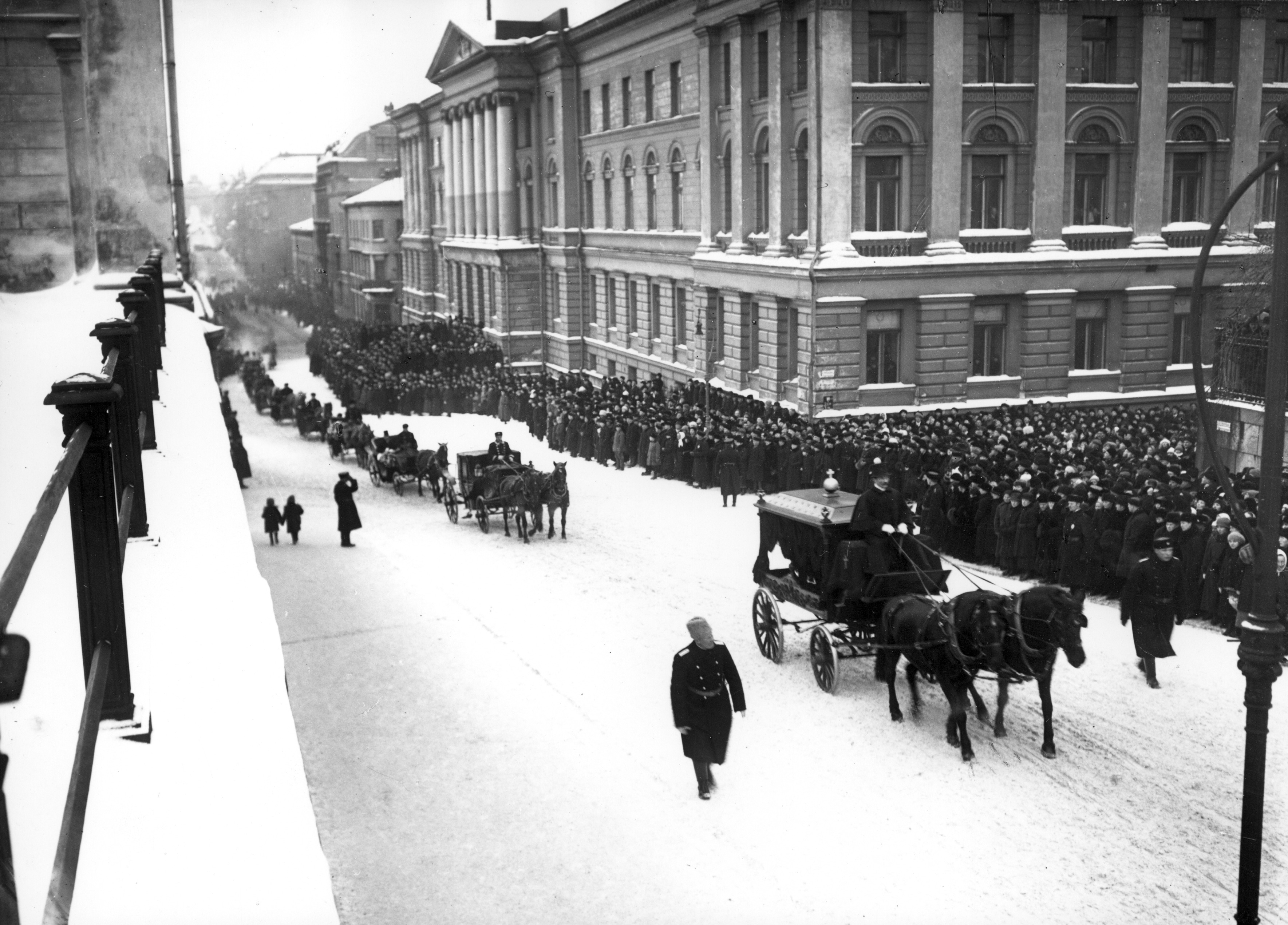 Murhatun sisäministeri Heikki Ritavuoren (1880-1922) hautajaisten surusaatto. Kulkue on juuri menossa Unioninkatua pohjoiseen, oik yliopisto, vas tuomiokirkon kaidetta.