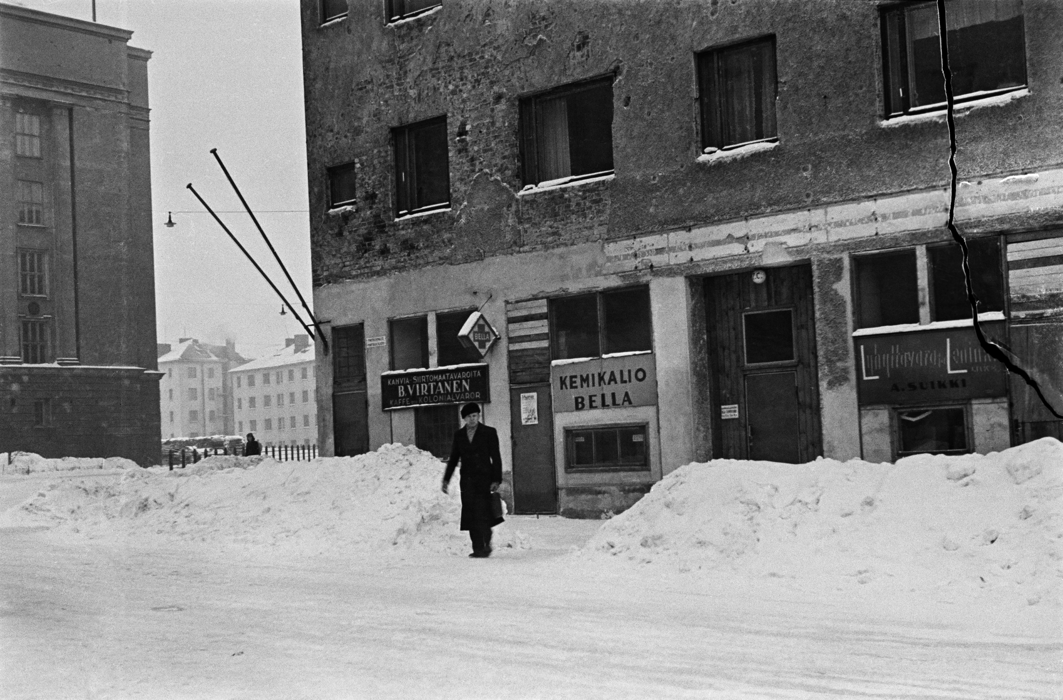 Porthaninkadun ja Agricolankadun risteys talvella. Porthaninkatu 17, katutasossa kahvi- ja siirtomaatavaraliike B. Virtanen, Kemikalio Bella sekä lyhyttavara- ja leninkiliike A. Suikki.